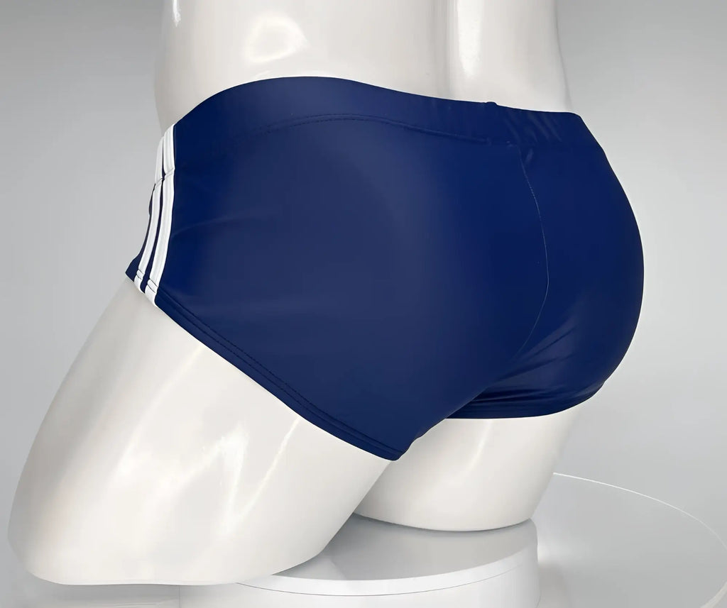 Navy blue swim brief on a mannequin, featuring two white side stripes and a fitted, low-cut athletic style.