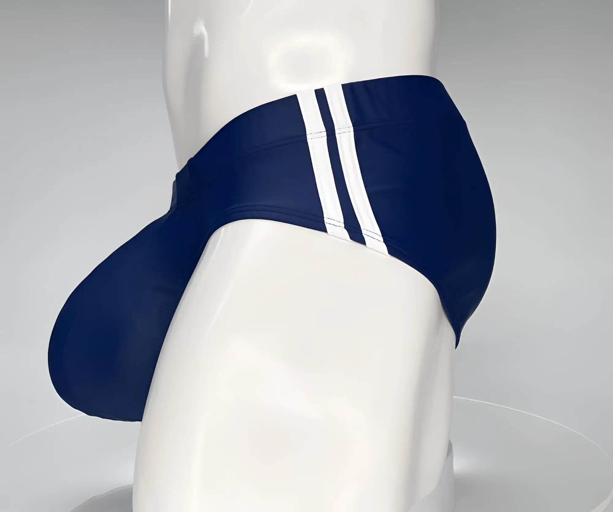 Navy WildmanT swim brief with white side stripes, featuring a contoured pouch design on a mannequin.