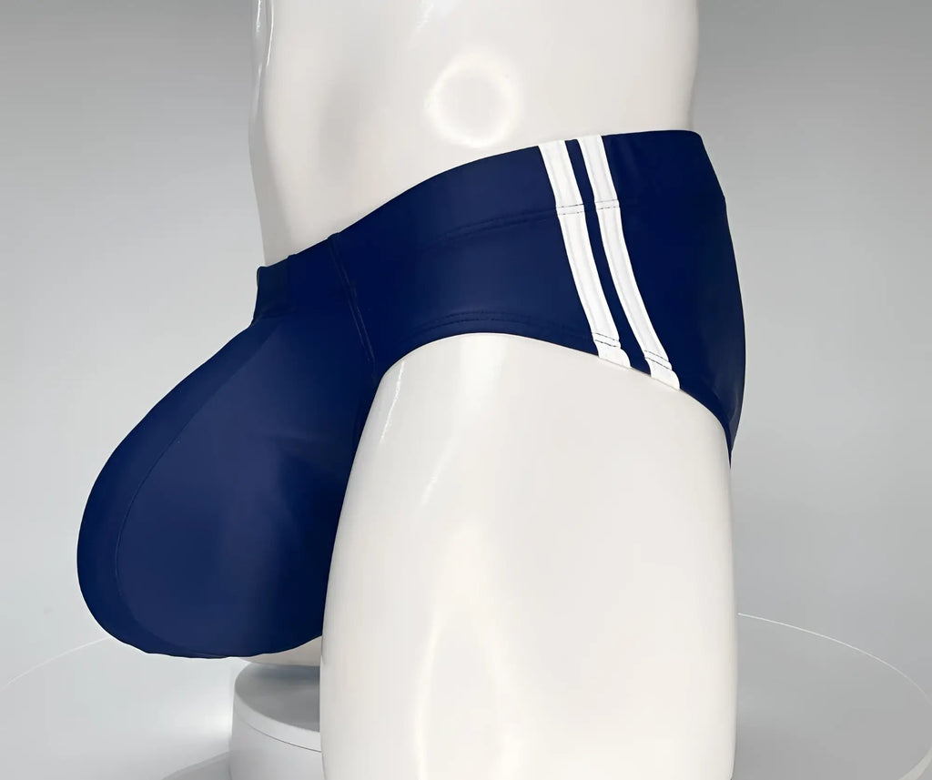Navy blue swim brief with a large, contoured pouch and dual white side stripes on a white mannequin torso.