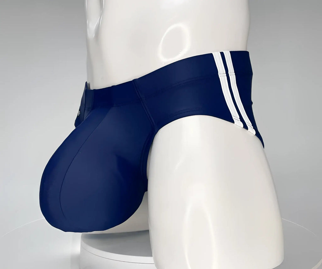 Navy blue WildmanT swim brief on a white mannequin featuring a contoured front pouch and double side stripes.