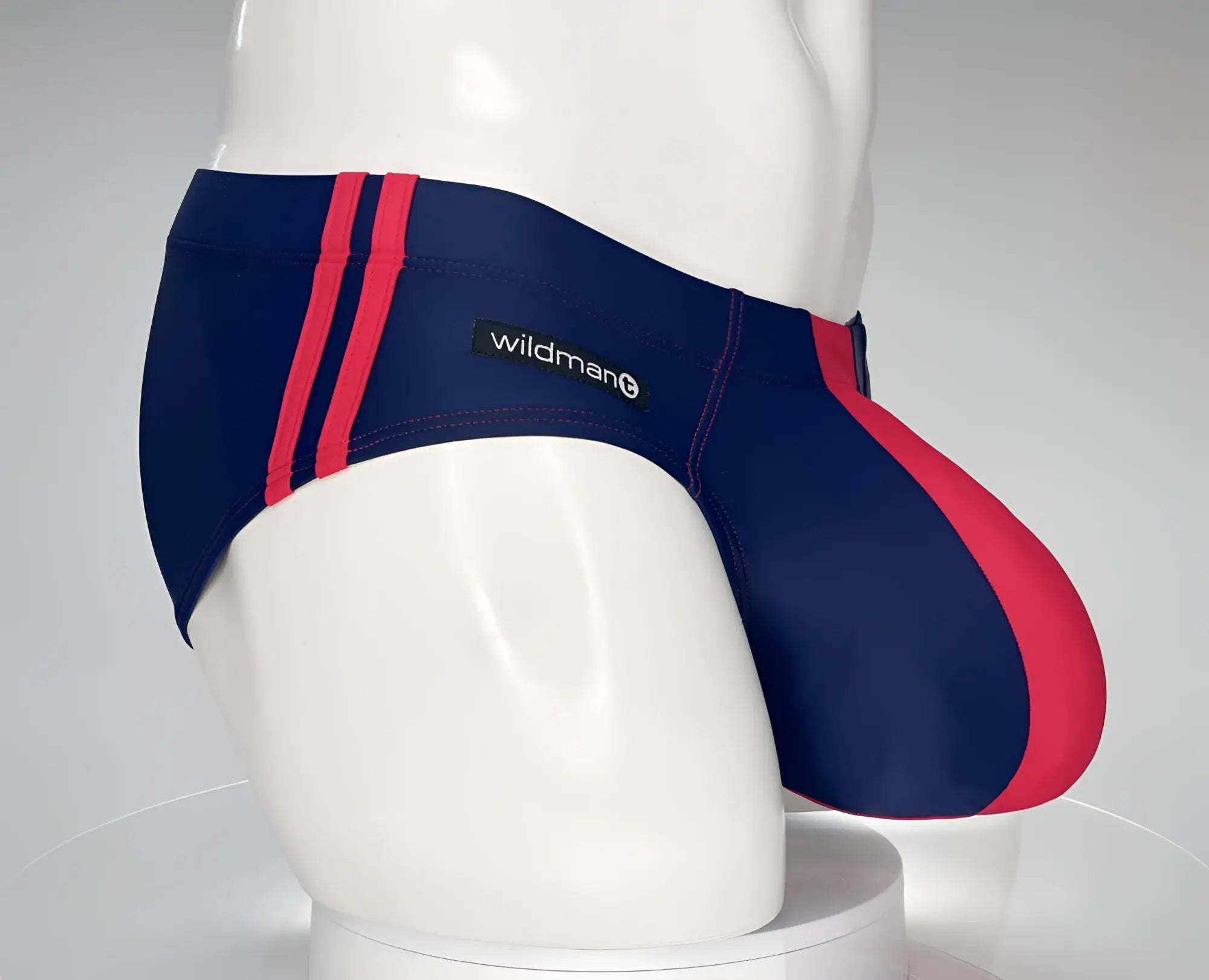 WildmanT navy and red swim brief with dual side stripes and a contoured pouch, modeled on a white mannequin.