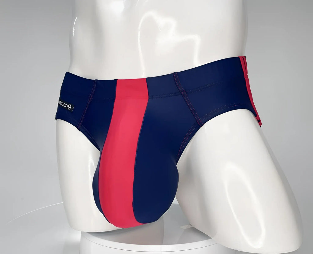 WildmanT navy and red swim brief with a prominent center panel and contrast stitching on a mannequin.