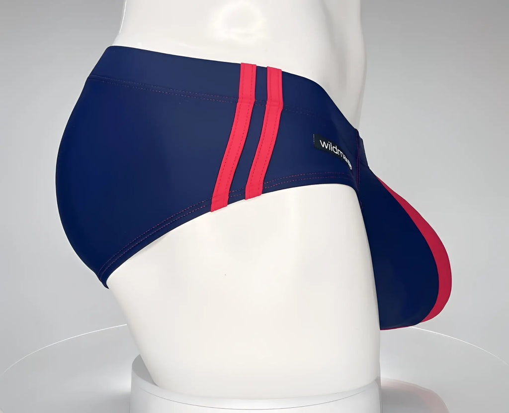 Navy blue swim brief with red side stripes and logo patch, shown from the side on a mannequin.