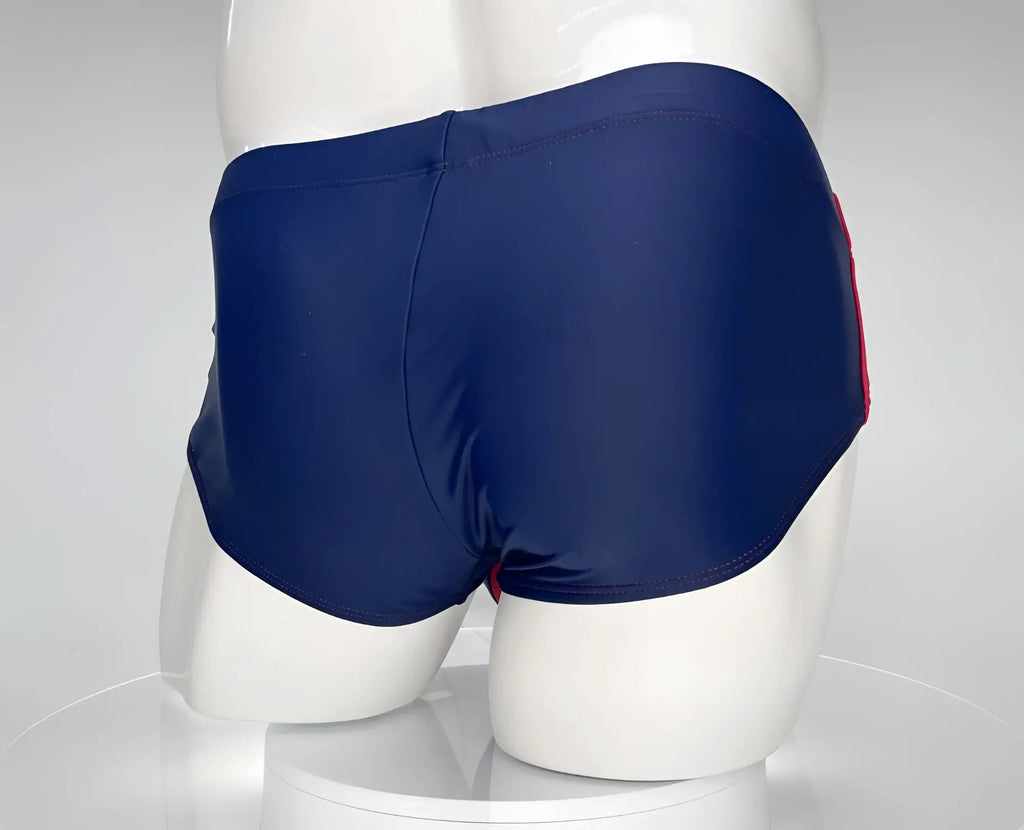 WildmanT navy blue swim brief with red side stripes and stitching, displayed on a white mannequin.