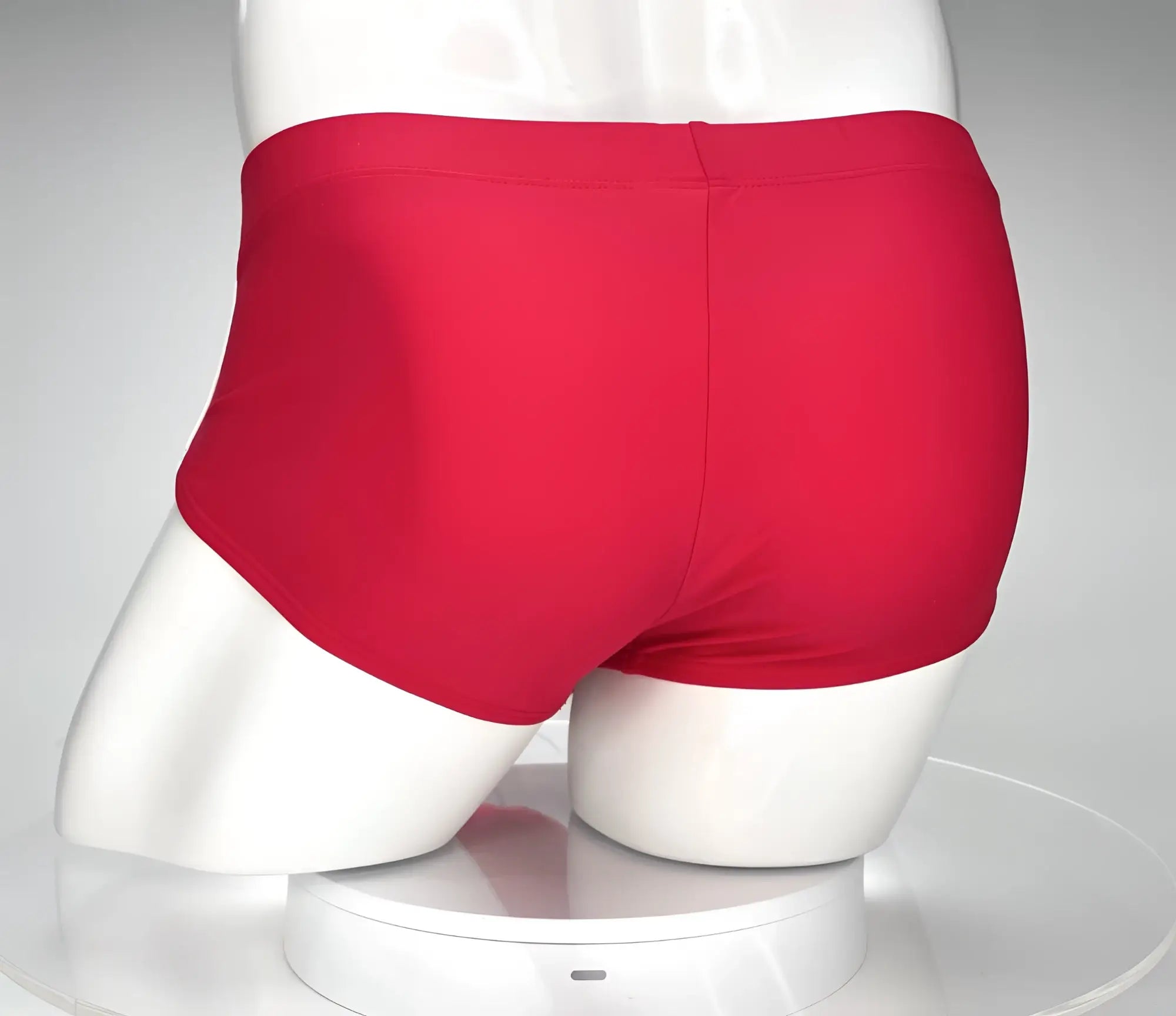 Back view of solid red WildmanT swim briefs on a white mannequin.