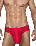 Red WildmanT swim brief with a contoured pouch and black logo tag on the hip, worn by a muscular man.
