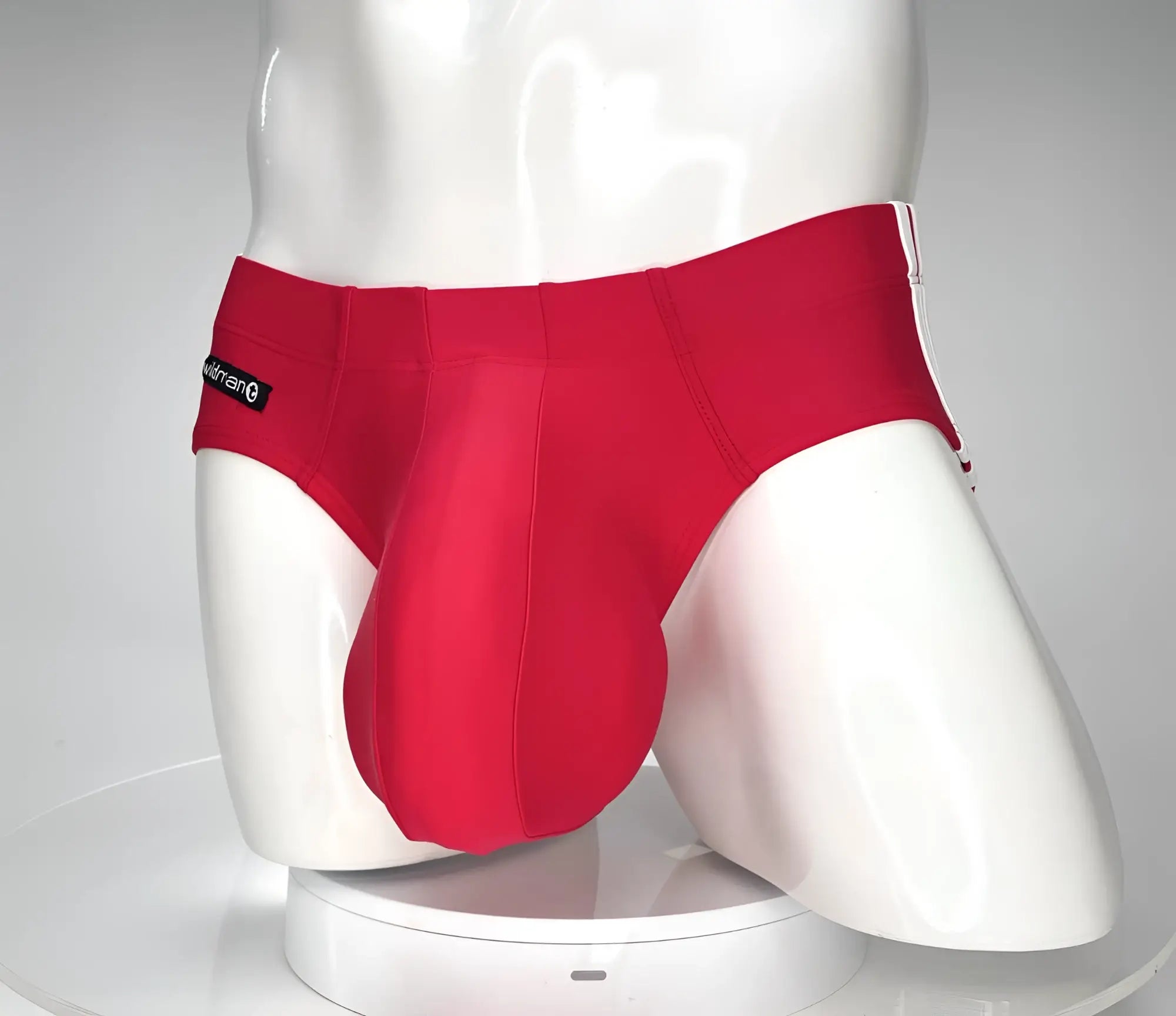 Red WildmanT swim brief with a prominent, contoured pouch, worn by a white male torso mannequin.