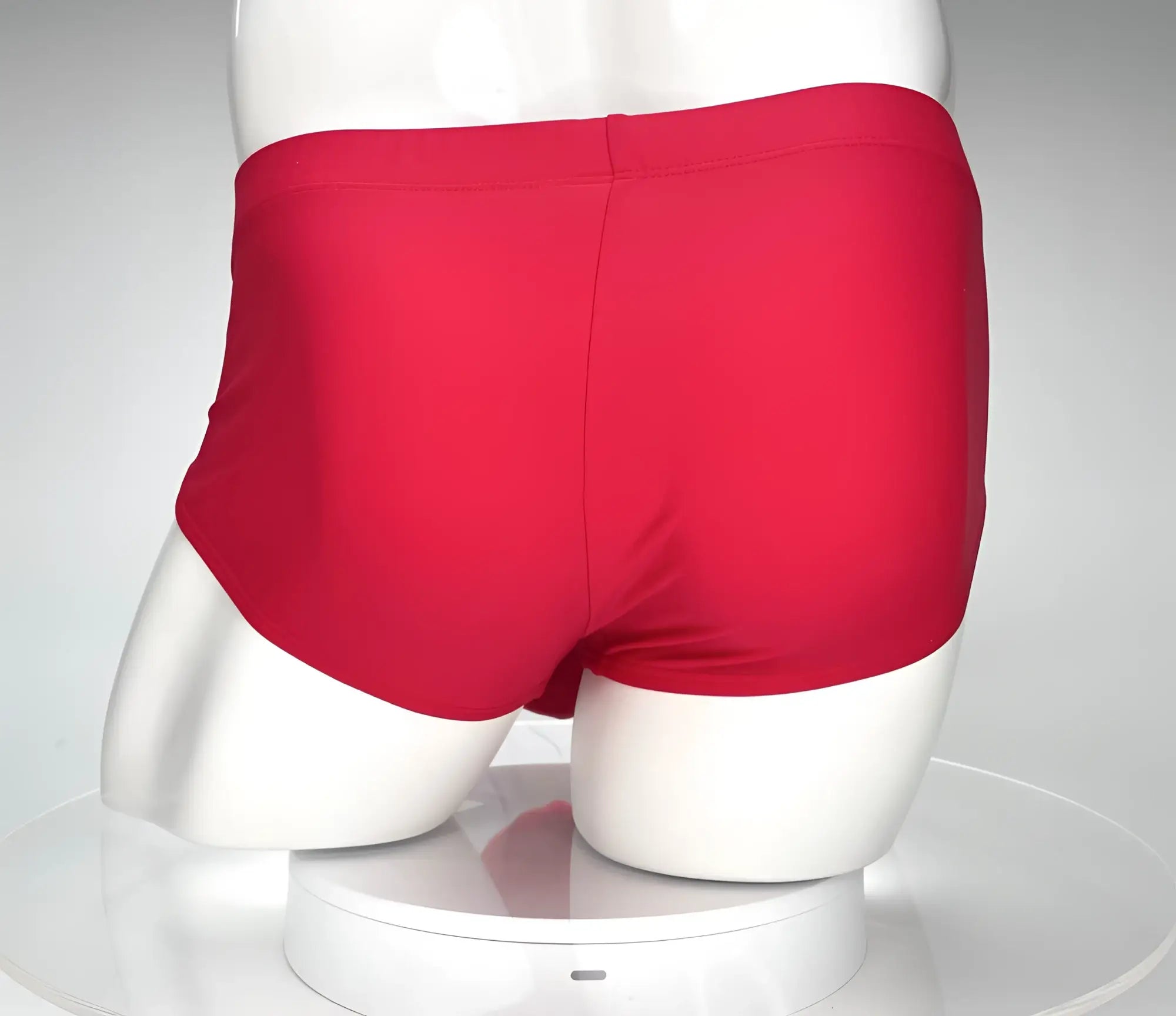 Back view of a solid red swim brief on a white mannequin.