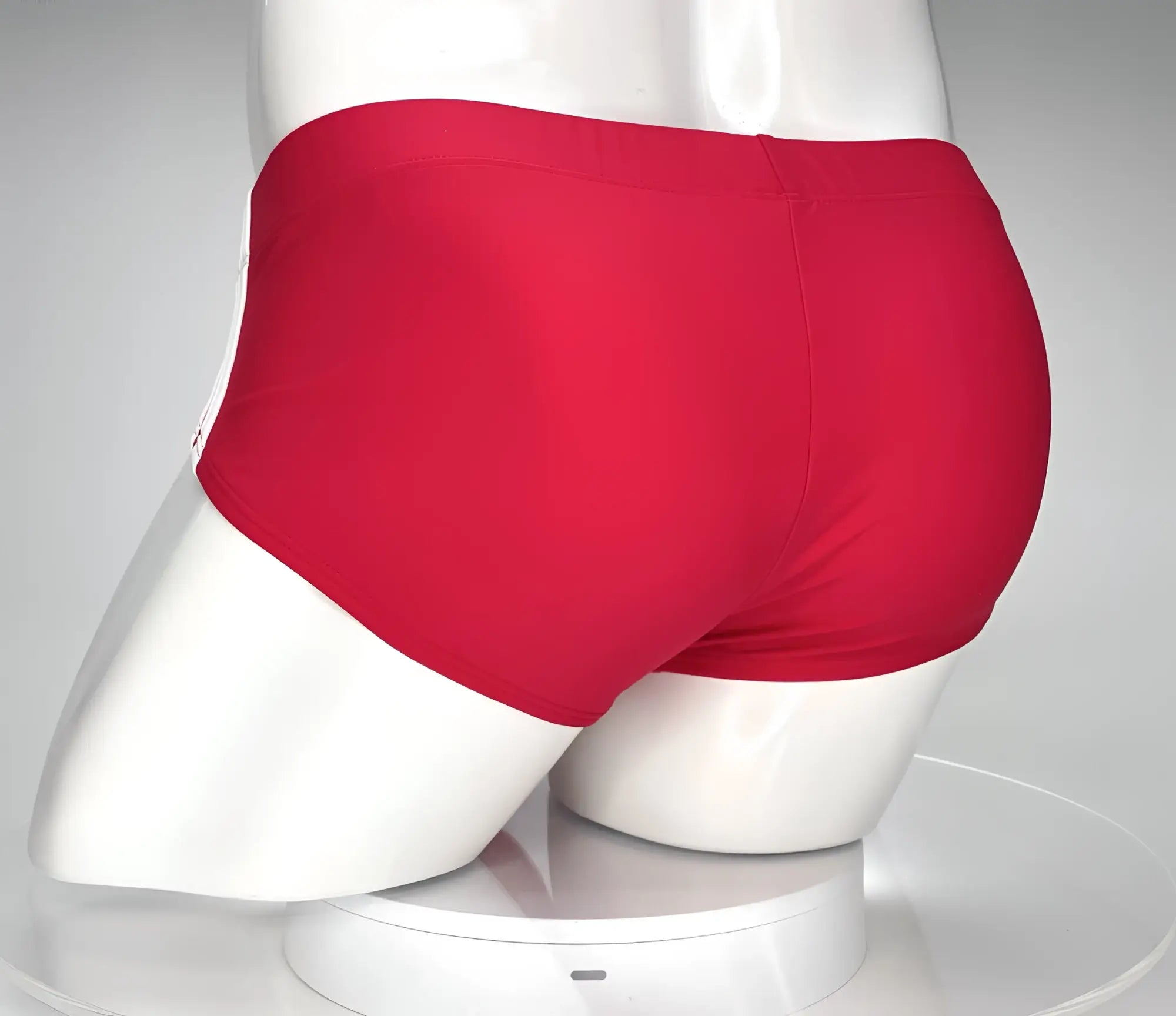 Back view of a red WildmanT swim brief with white side detail, worn by a white mannequin torso.