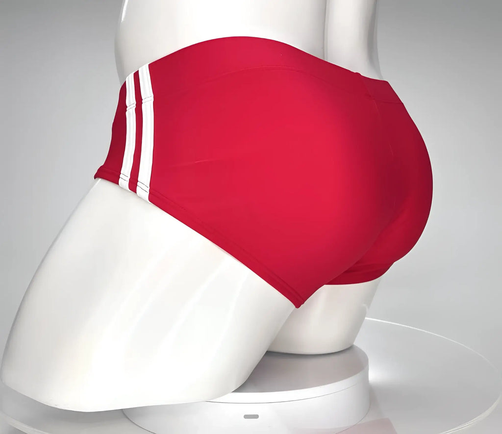 Red swim brief on a white mannequin featuring a low-rise fit and two vertical white stripes on the side.