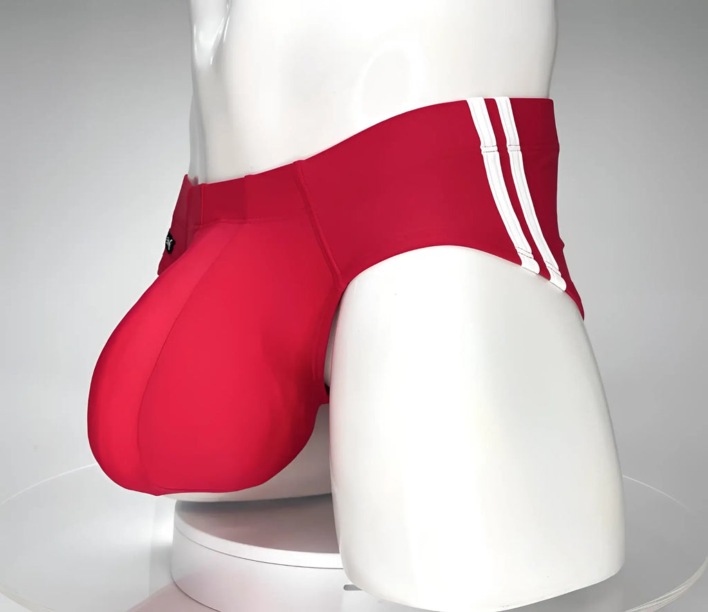 Red swim brief on a mannequin, featuring an extra-large contoured pouch and dual white side stripes.