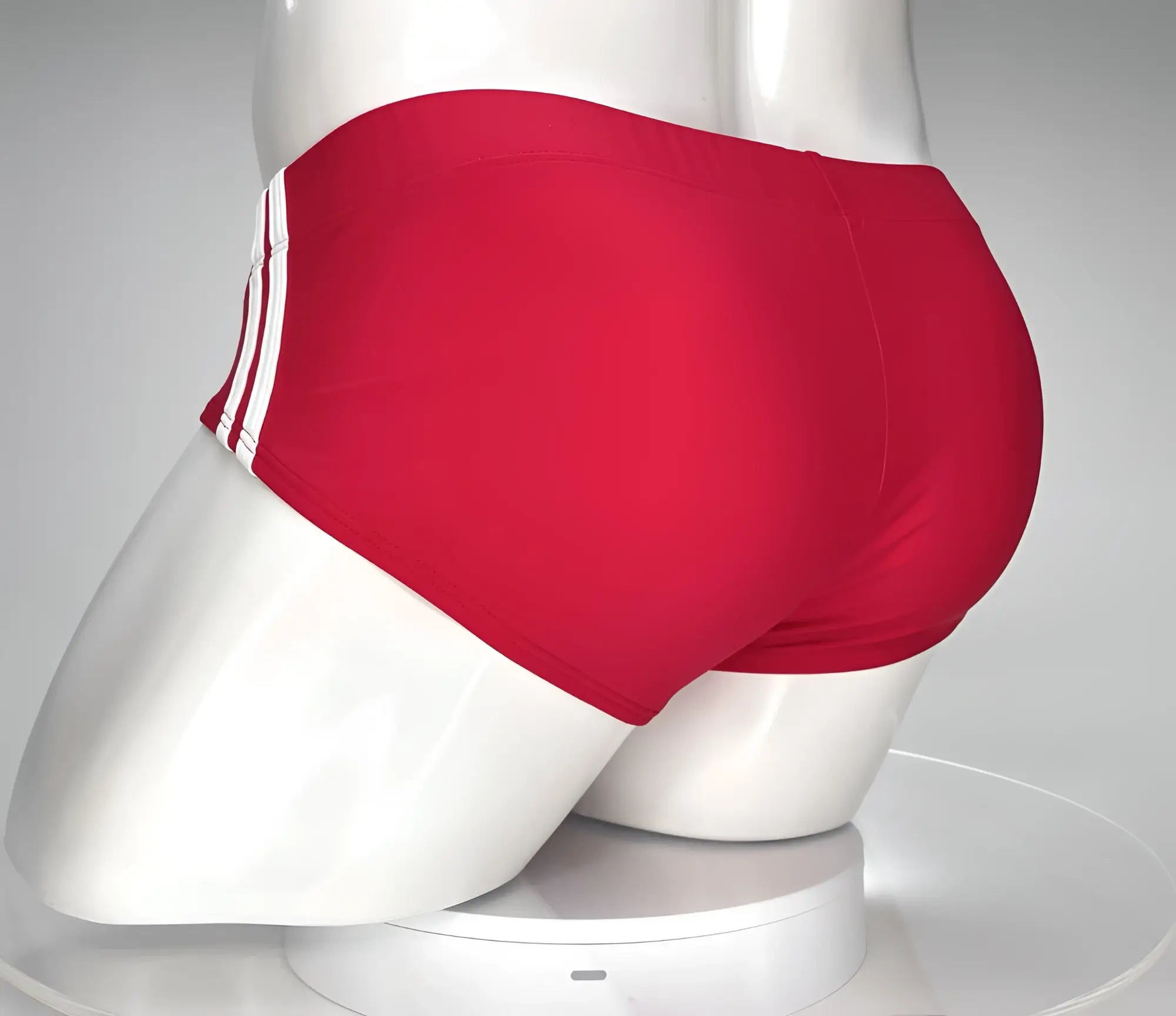 Red swim brief on a mannequin, featuring two white side stripes, viewed from the back.