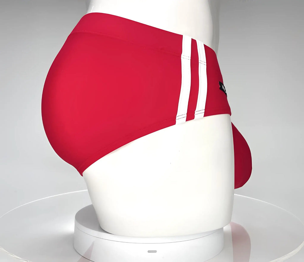 WildmanT red swim brief on a white mannequin featuring two white side stripes and a contoured front pouch.