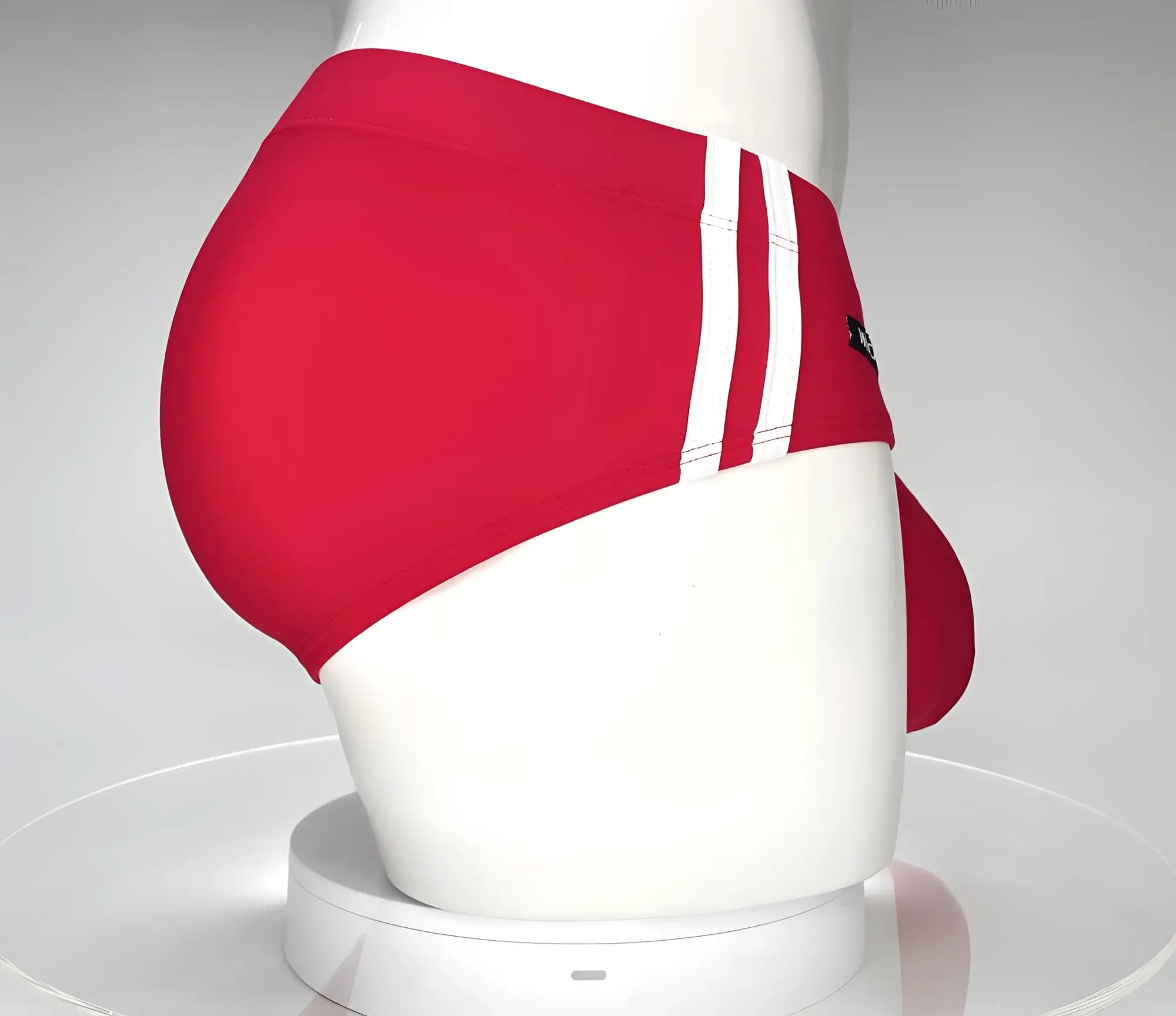 WildmanT red swim brief on a white mannequin featuring two white side stripes and a contoured front pouch.