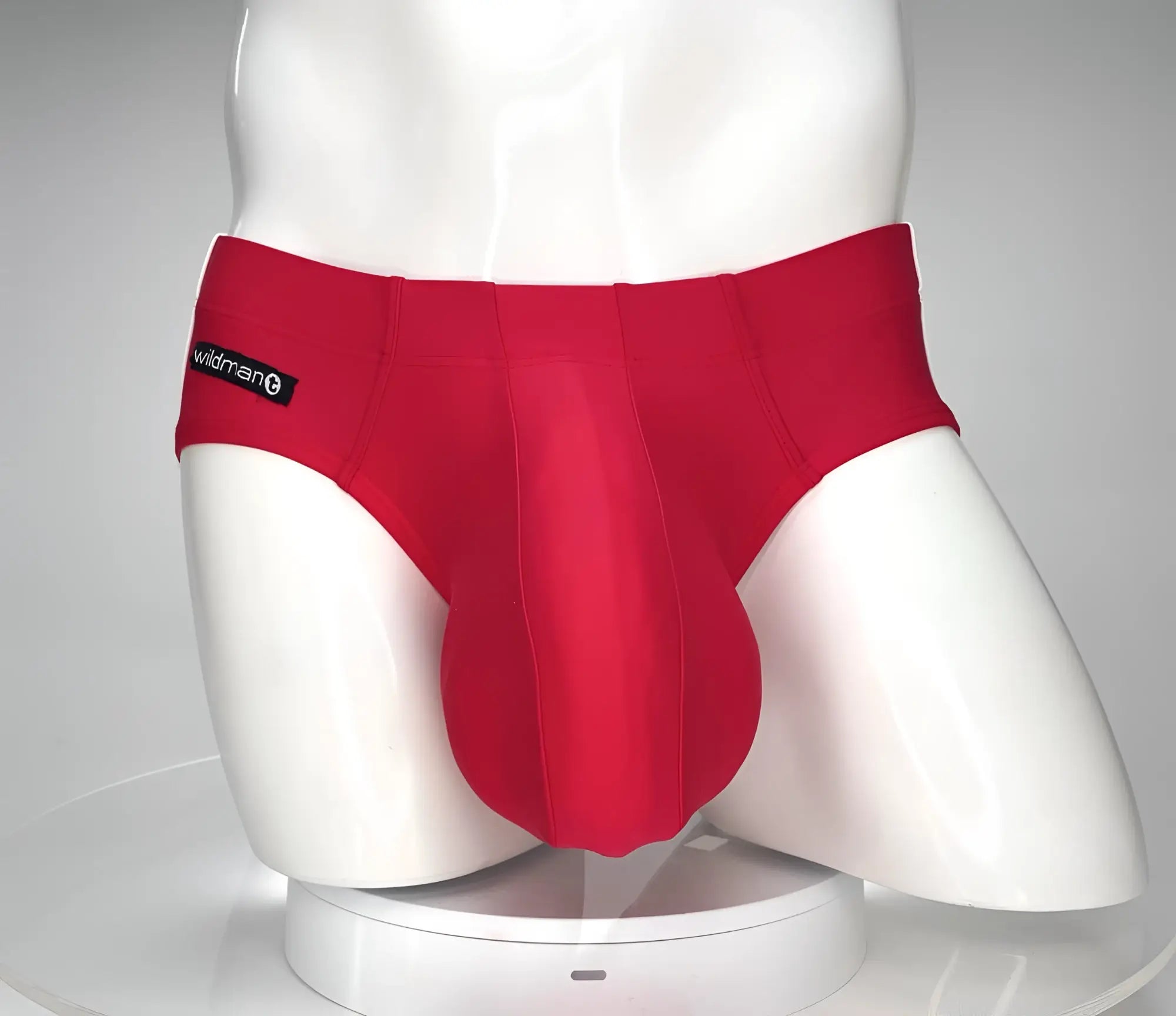 Red WildmanT swim brief with a prominent, contoured pouch on a white mannequin torso.