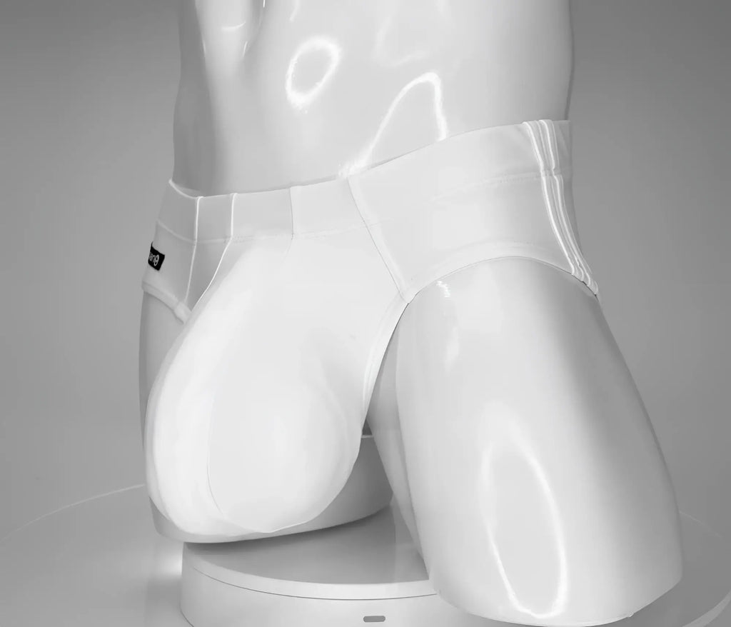 White low-rise swim brief with an enhanced, contoured pouch on a glossy white mannequin.