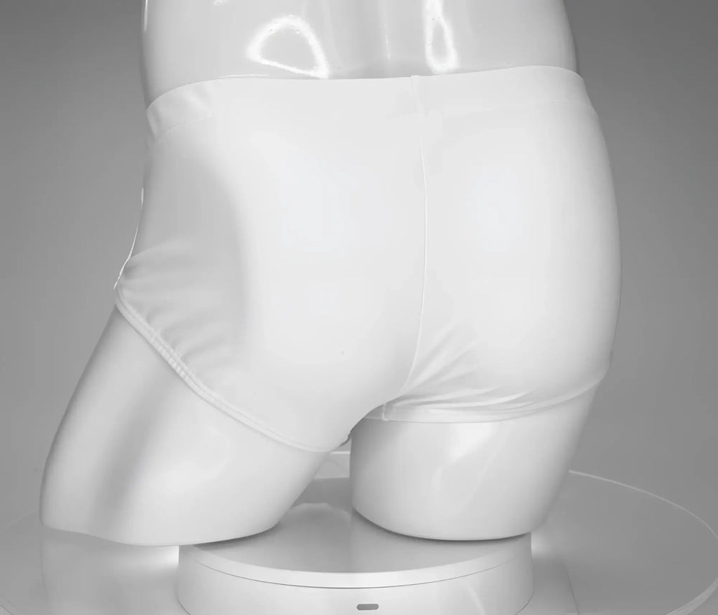 Back view of a plain white WildmanT swim brief on a white mannequin torso against a gray background.