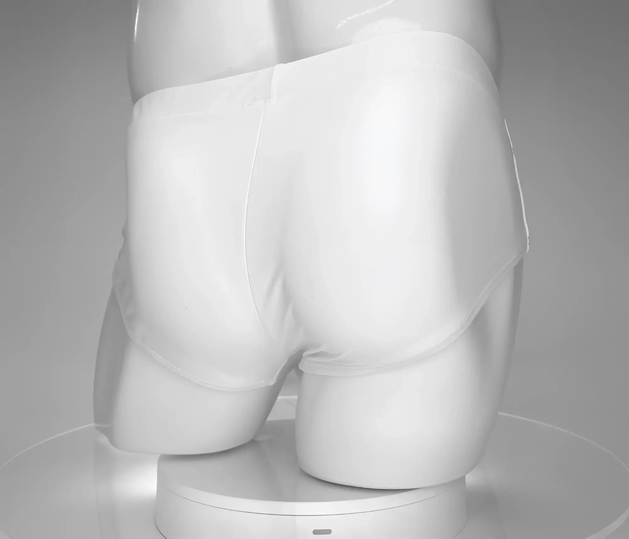 Rear view of white WildmanT swim briefs on a mannequin, featuring full back coverage and smooth fabric.