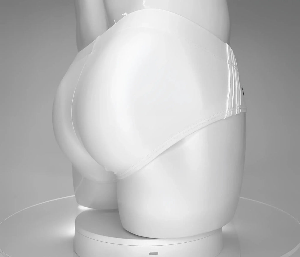 Back view of white WildmanT swim briefs on a mannequin, featuring a smooth fit and side striped detailing.