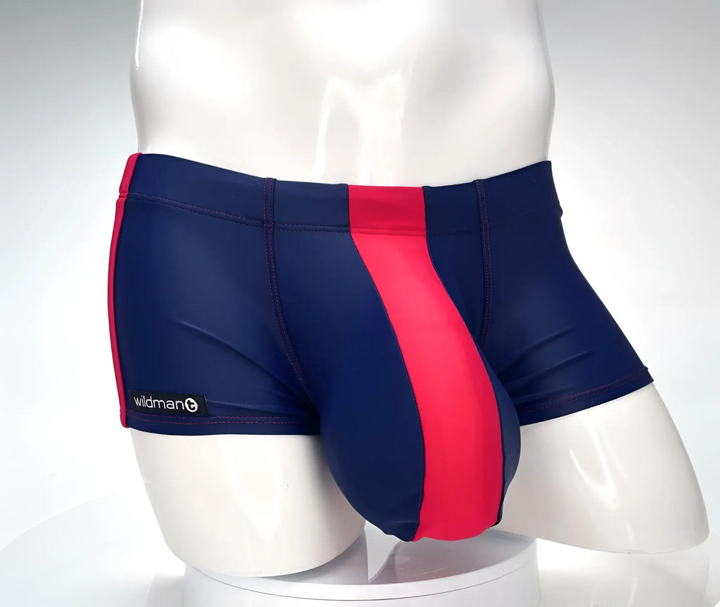 WildmanT navy blue square-cut swim trunks featuring a prominent red front panel and red side stripe on a mannequin.