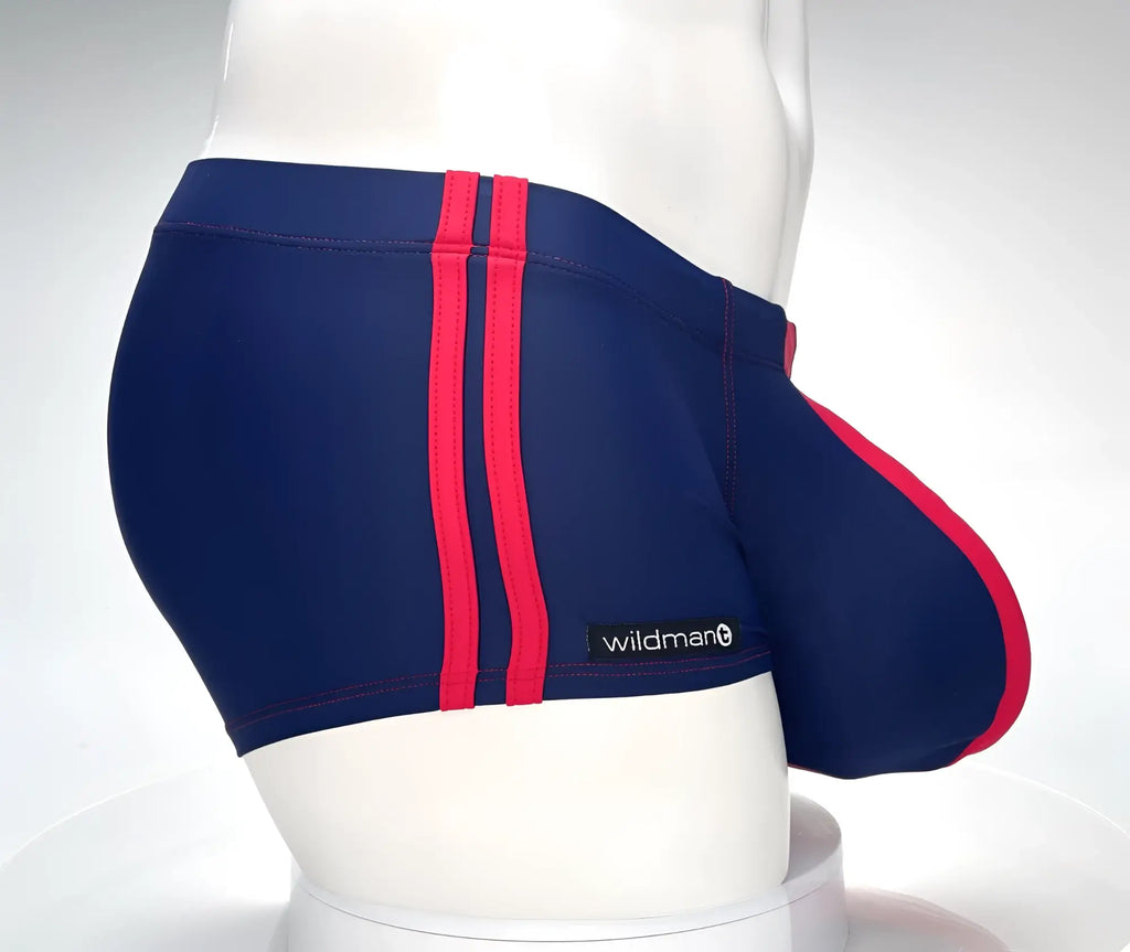 Navy blue square-cut swim trunks with red side stripes and a red-trimmed front pouch, on a white mannequin.