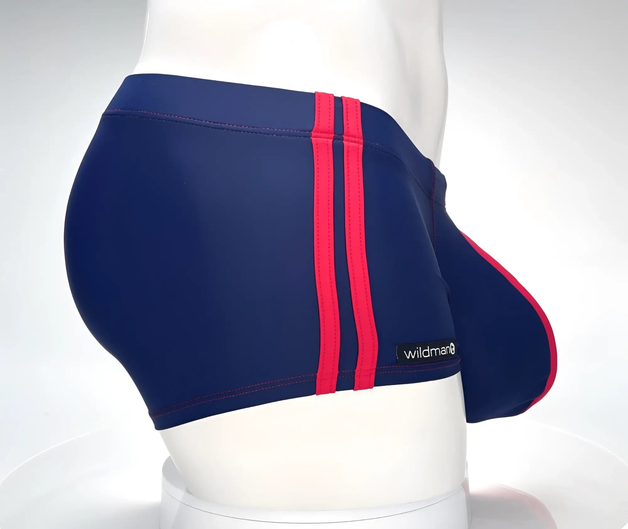 Navy blue square-cut swim trunks with two red side stripes and a contoured pouch, featuring a small WildmanT logo tag.