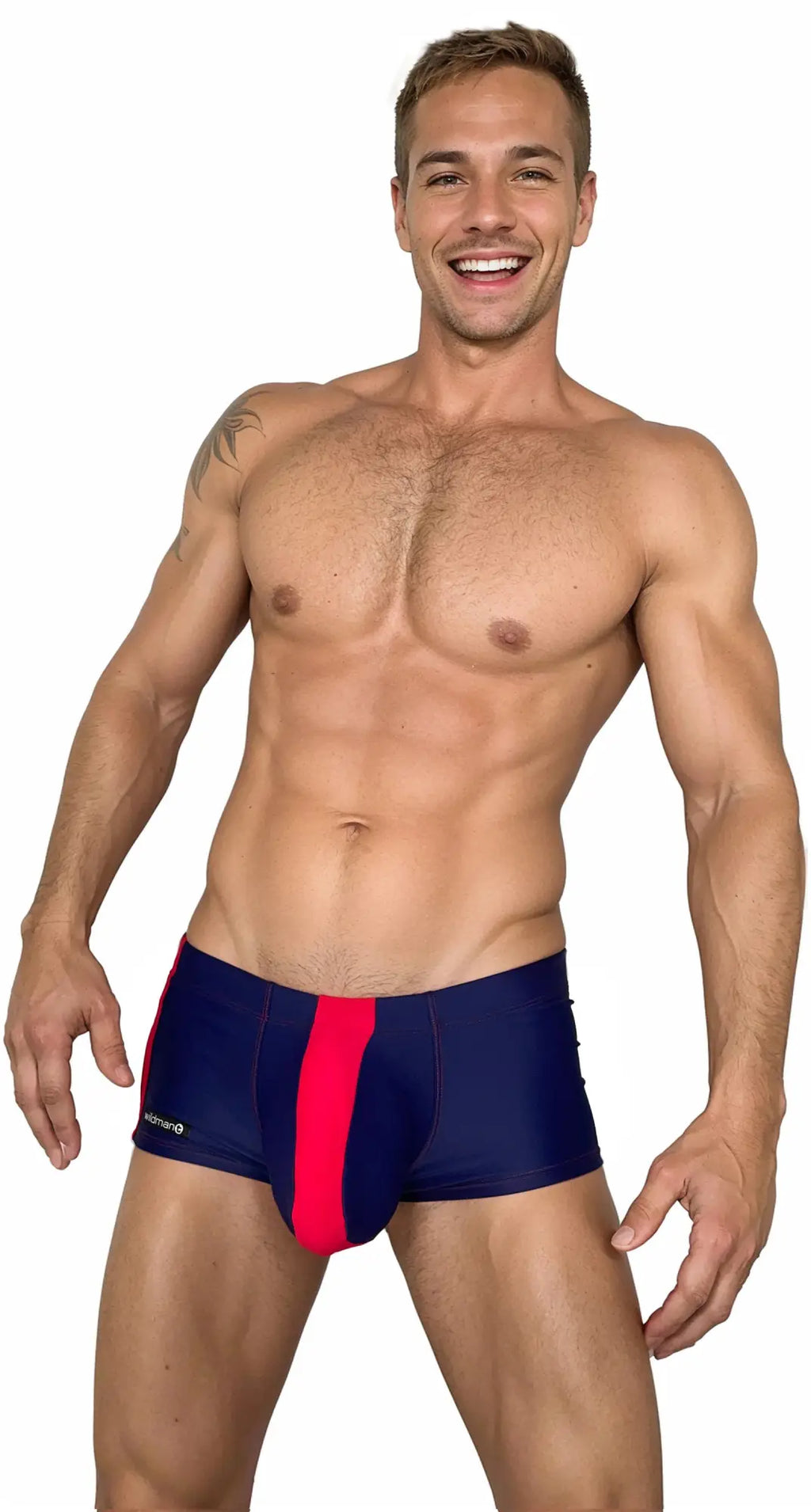 A smiling model wears WildmanT navy blue square-cut swim trunks with a bright red vertical stripe down the center.