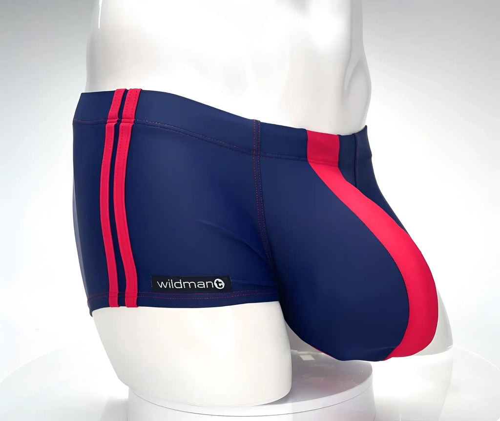 Navy and red square-cut swim trunks with double red side stripes and a contoured pouch on a white mannequin.
