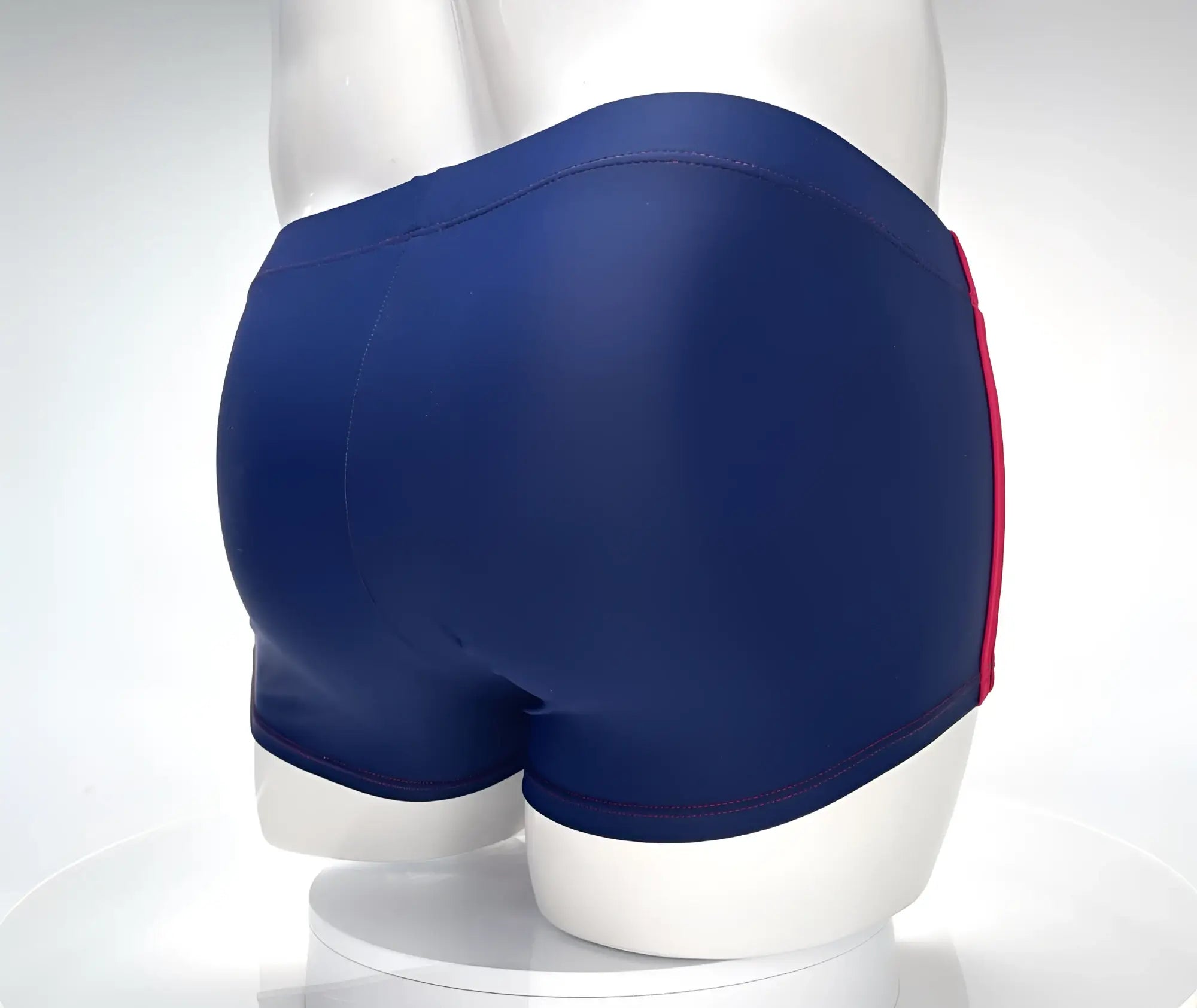 WildmanT navy blue square-cut swim trunks on a mannequin, featuring red side stripes and red contrast stitching.
