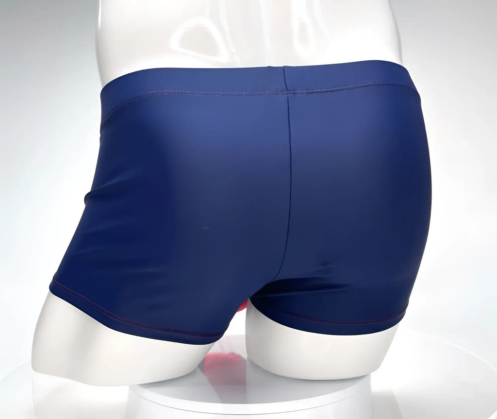 Navy square-cut swim trunks with red contrast stitching, shown from the back on a white mannequin.