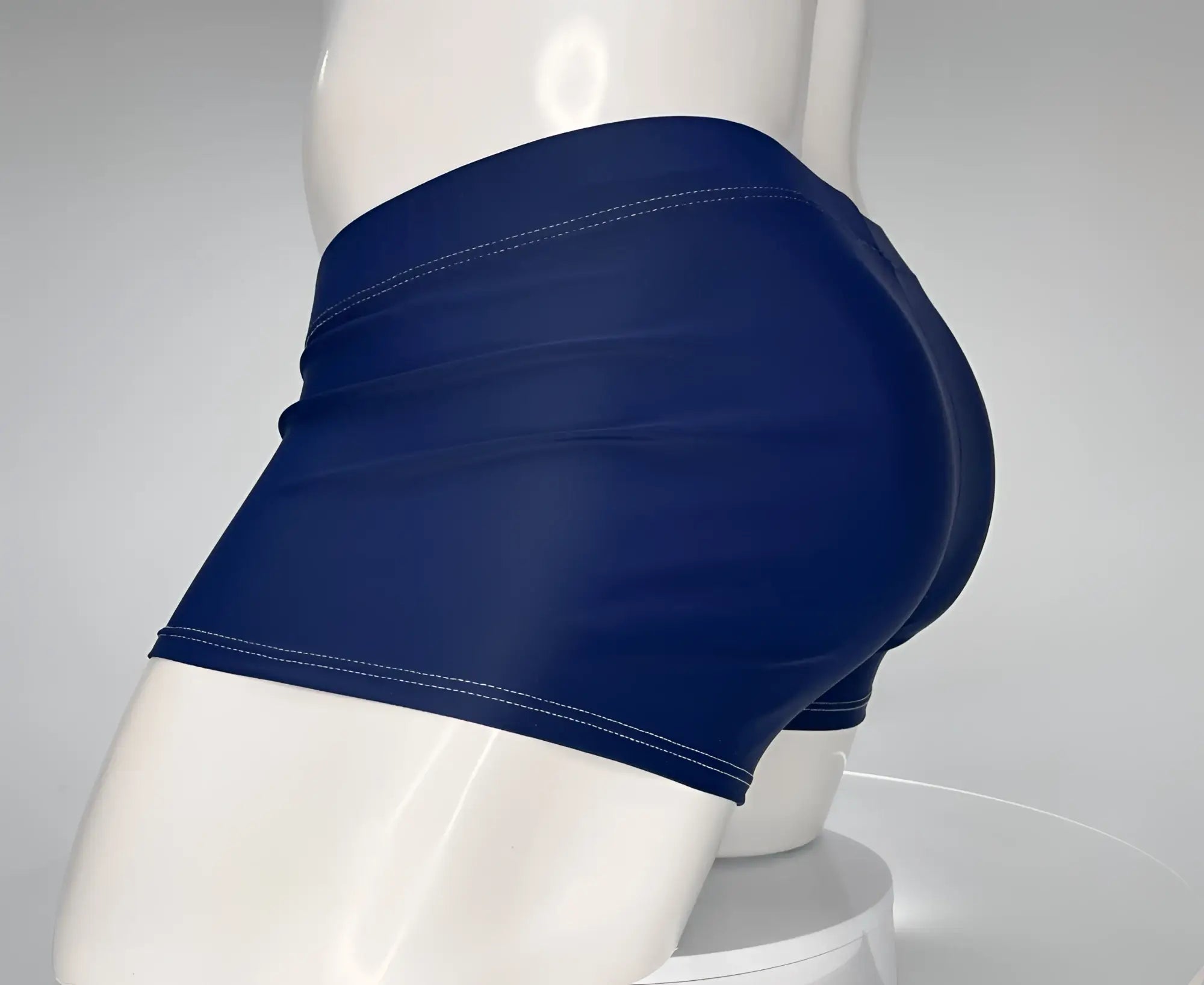 Side view of navy blue square-cut swim trunks with white topstitching, worn on a white mannequin.