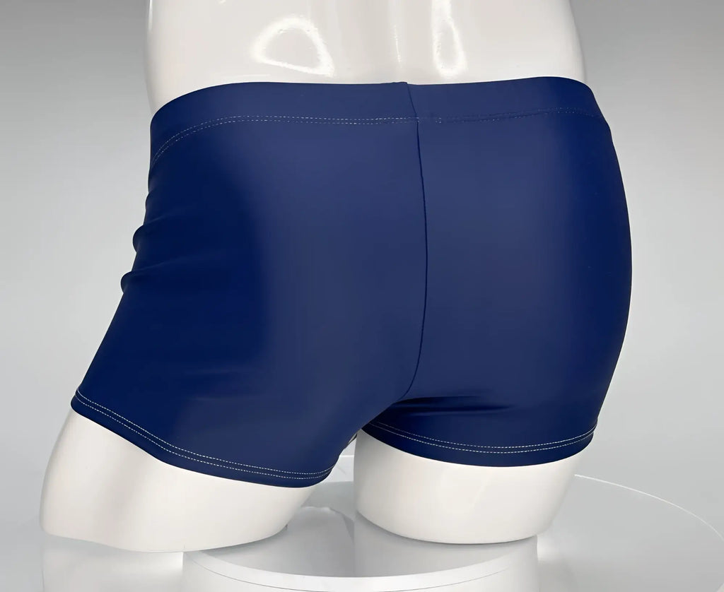 Navy blue square-cut swim trunks with white topstitching shown from the back on a white mannequin.