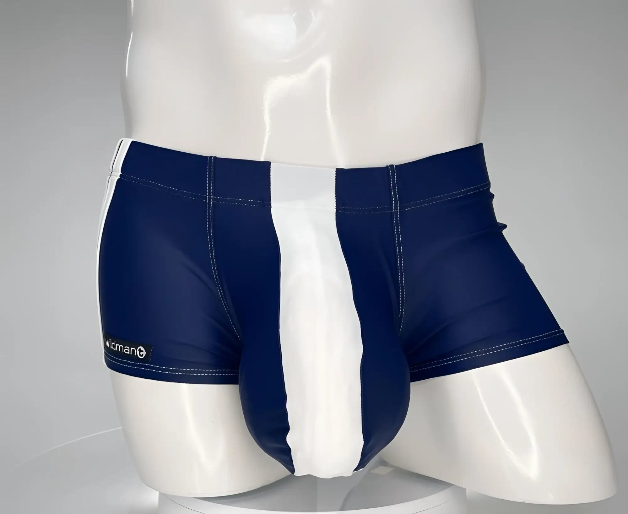 WildmanT navy and white square-cut swim trunks with a prominent center pouch on a white mannequin torso.