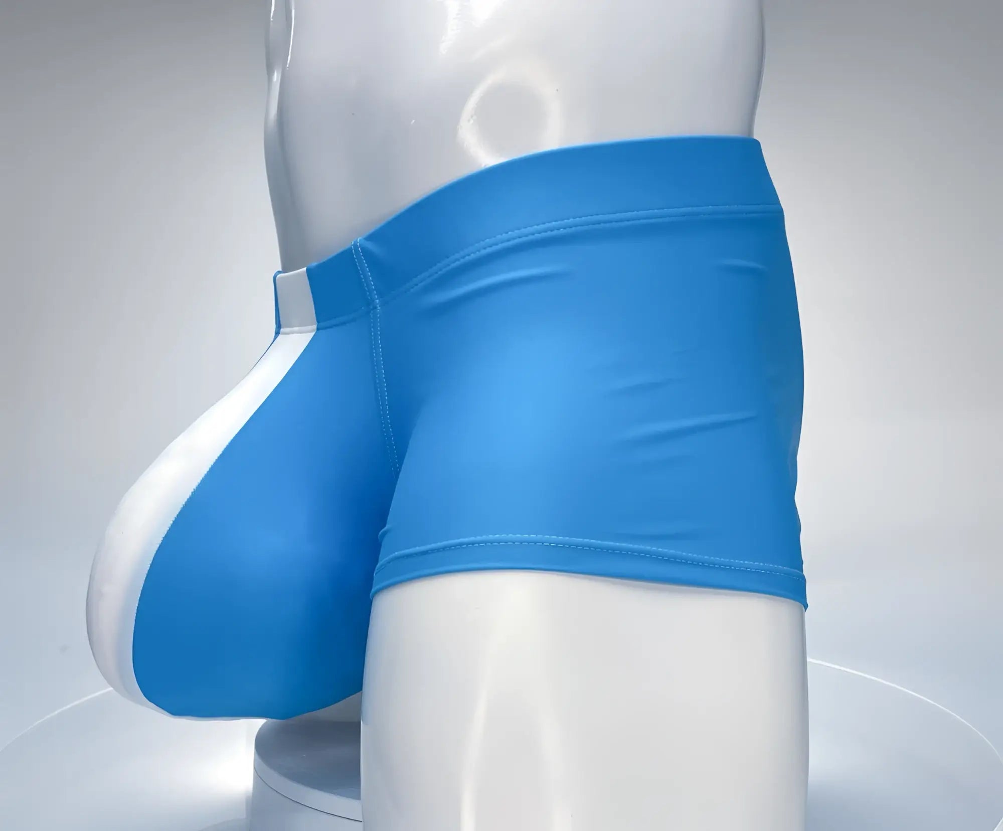 Teal and white WildmanT square cut swim trunks on a mannequin, featuring a contoured front pouch.