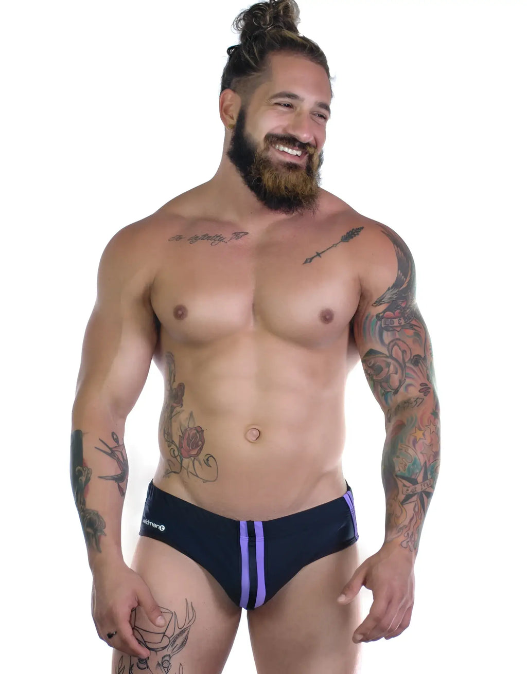 Sportivo bikini in black with vertical purple side stripes, worn by a muscular, tattooed man on a white background.