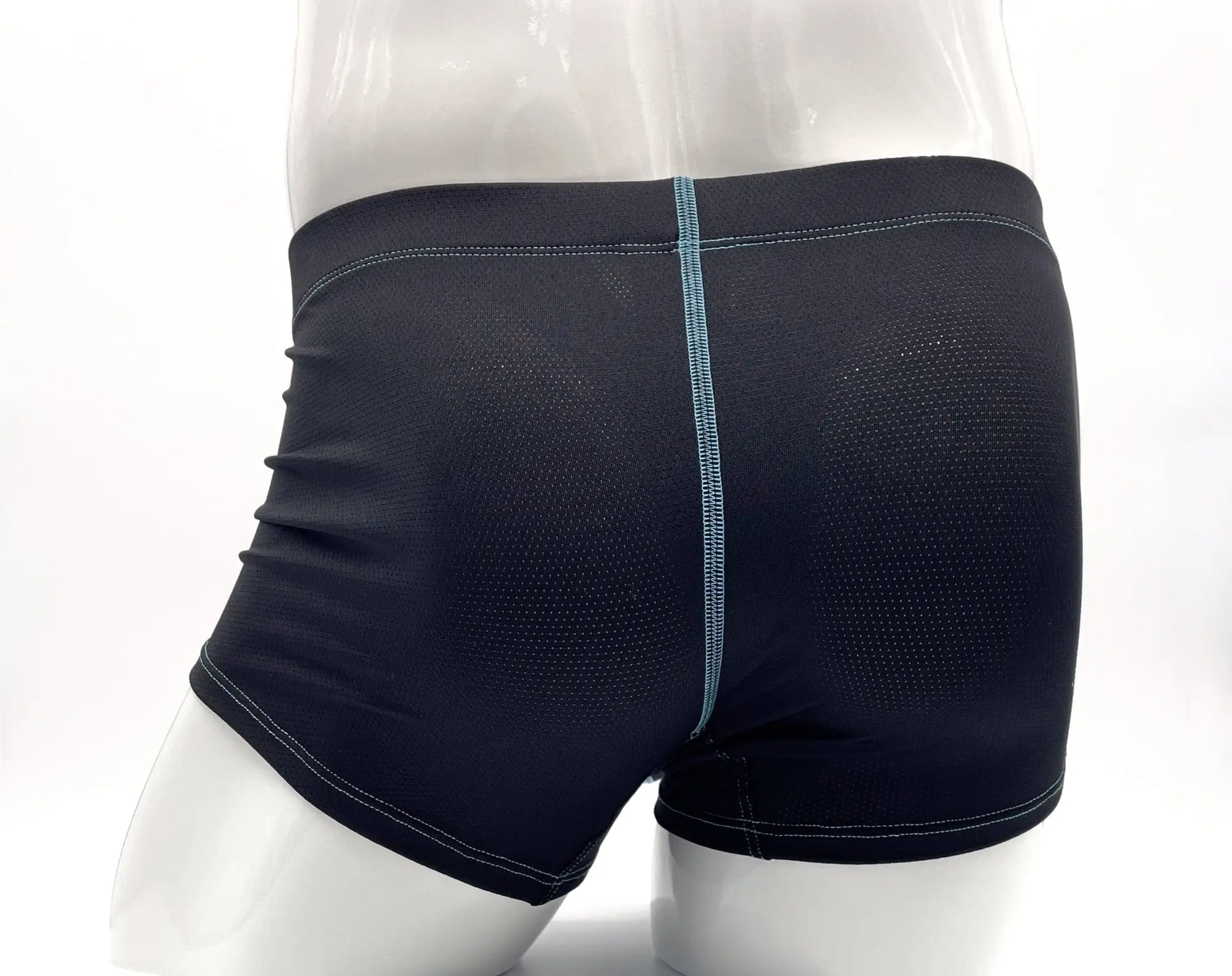 Back view of dark navy perforated boxer briefs with a vertical light blue stitched seam on a white mannequin.