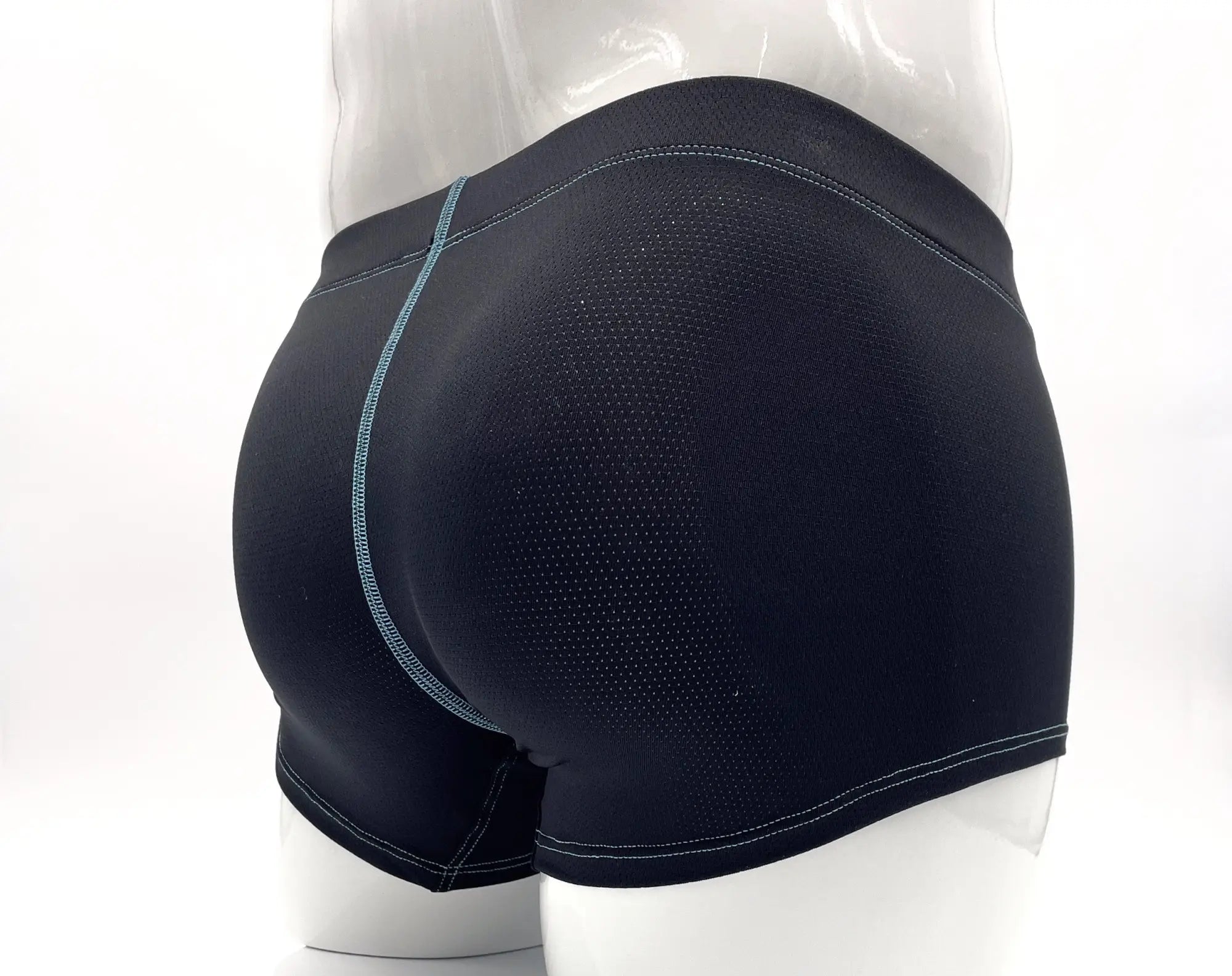 Back view of black perforated boxer briefs with contrast light blue stitching on a mannequin.