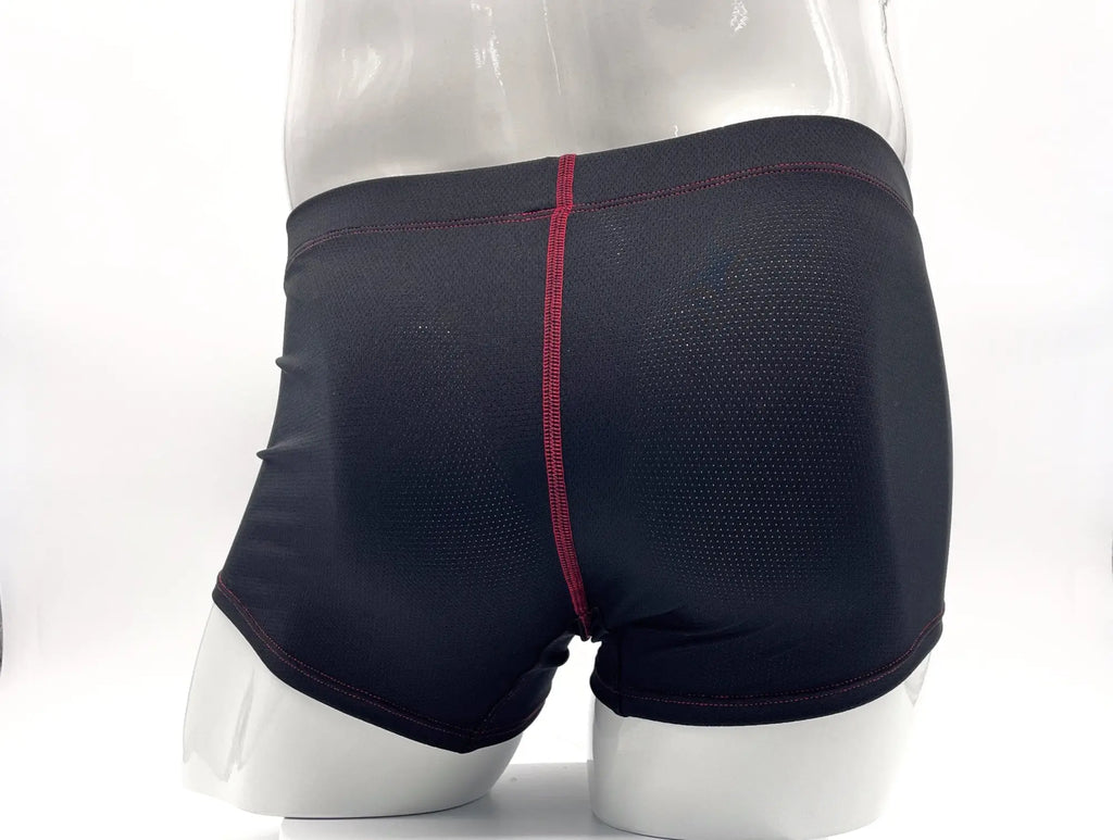 Black mesh boxer briefs on a mannequin with red contrast stitching down the center and along the hems.