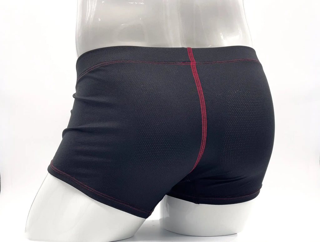 Black boxer briefs on a mannequin, featuring textured fabric and prominent red stitching details along the seams.