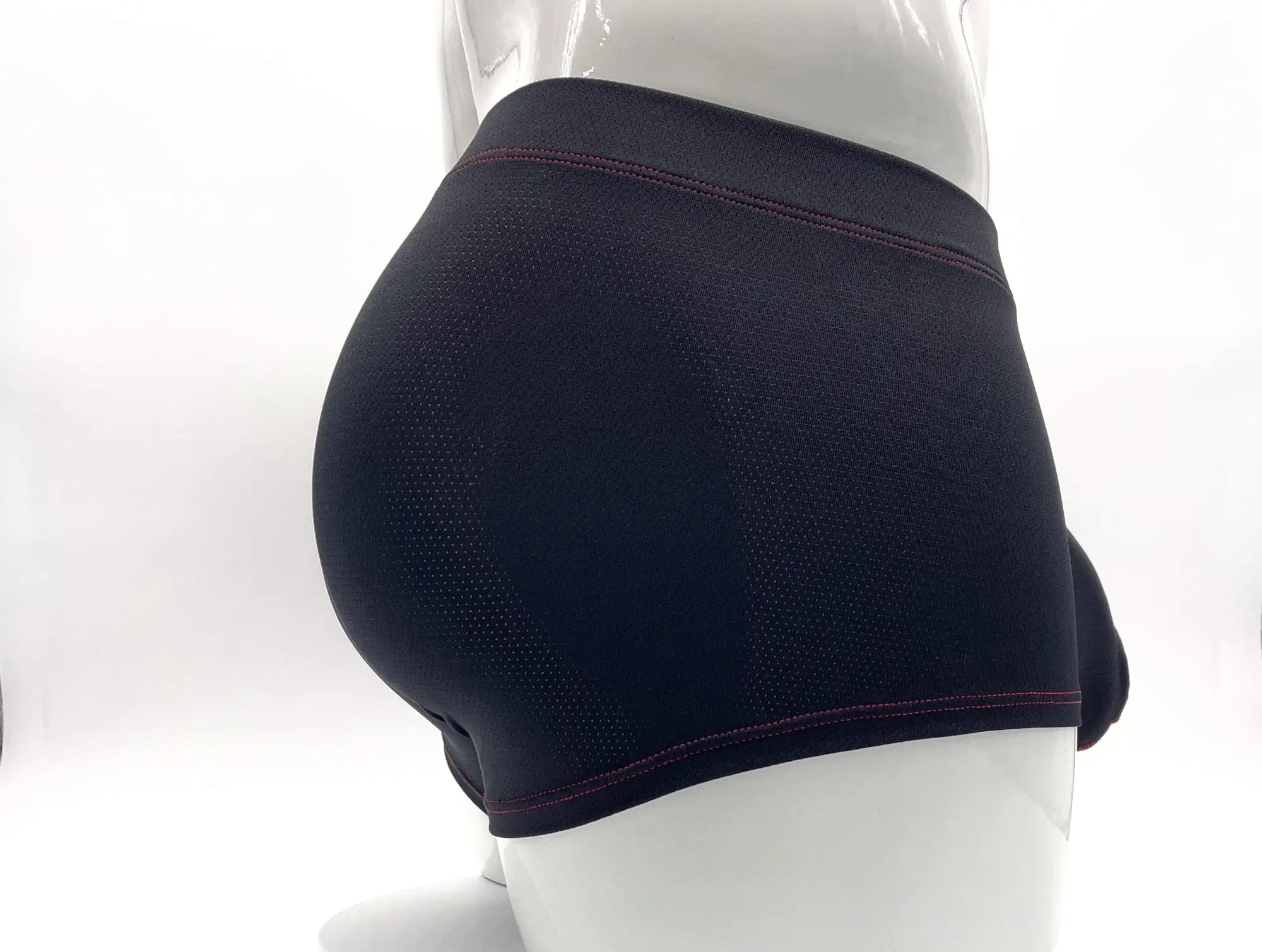 Black microfiber pouch boxer briefs on a white mannequin, featuring contrast red stitching along the waistband and hem.