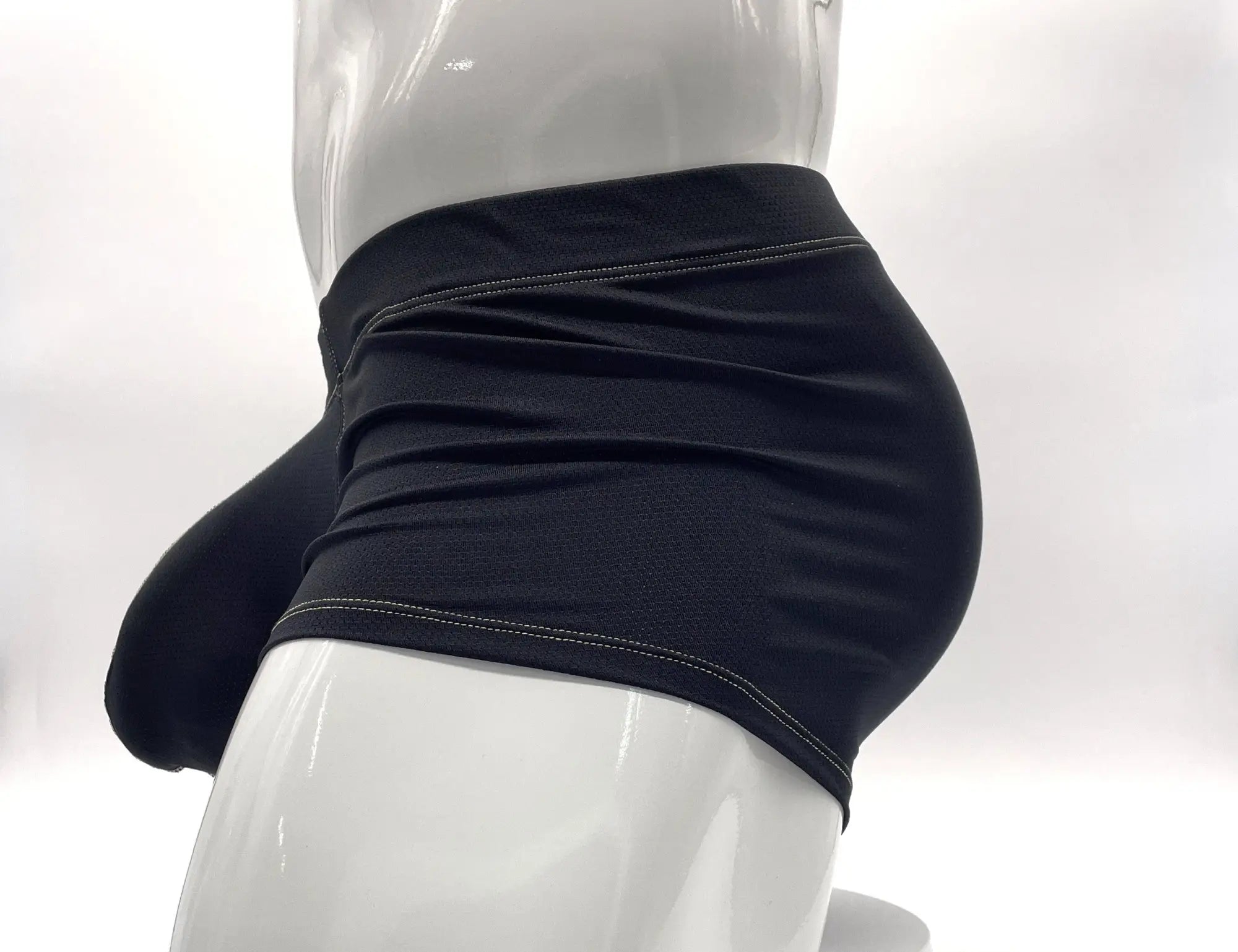 Black pouch boxer briefs with yellow stitching on a mannequin, shown from a side profile view.