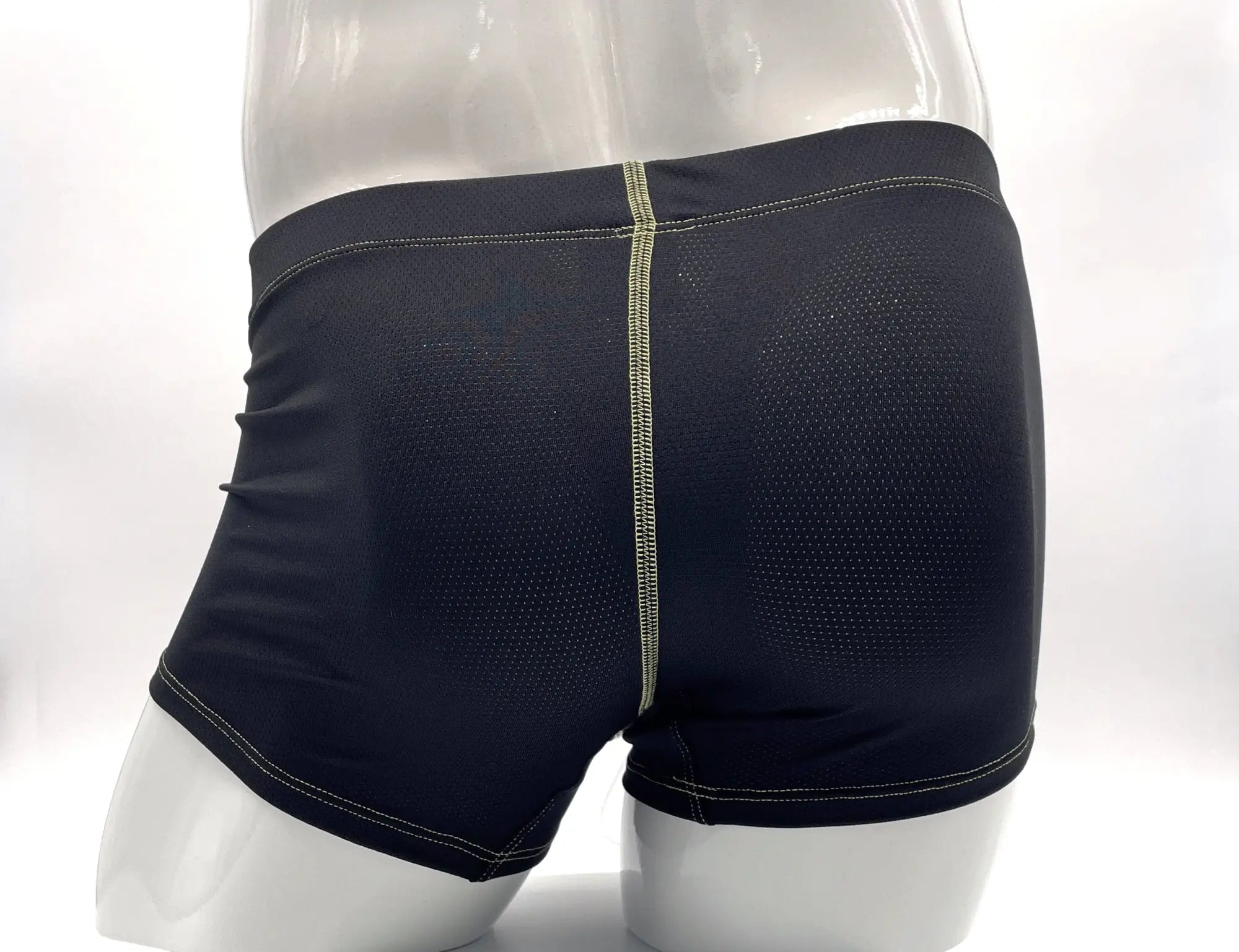 Black mesh boxer briefs with visible yellow stitching, shown from the rear on a mannequin.