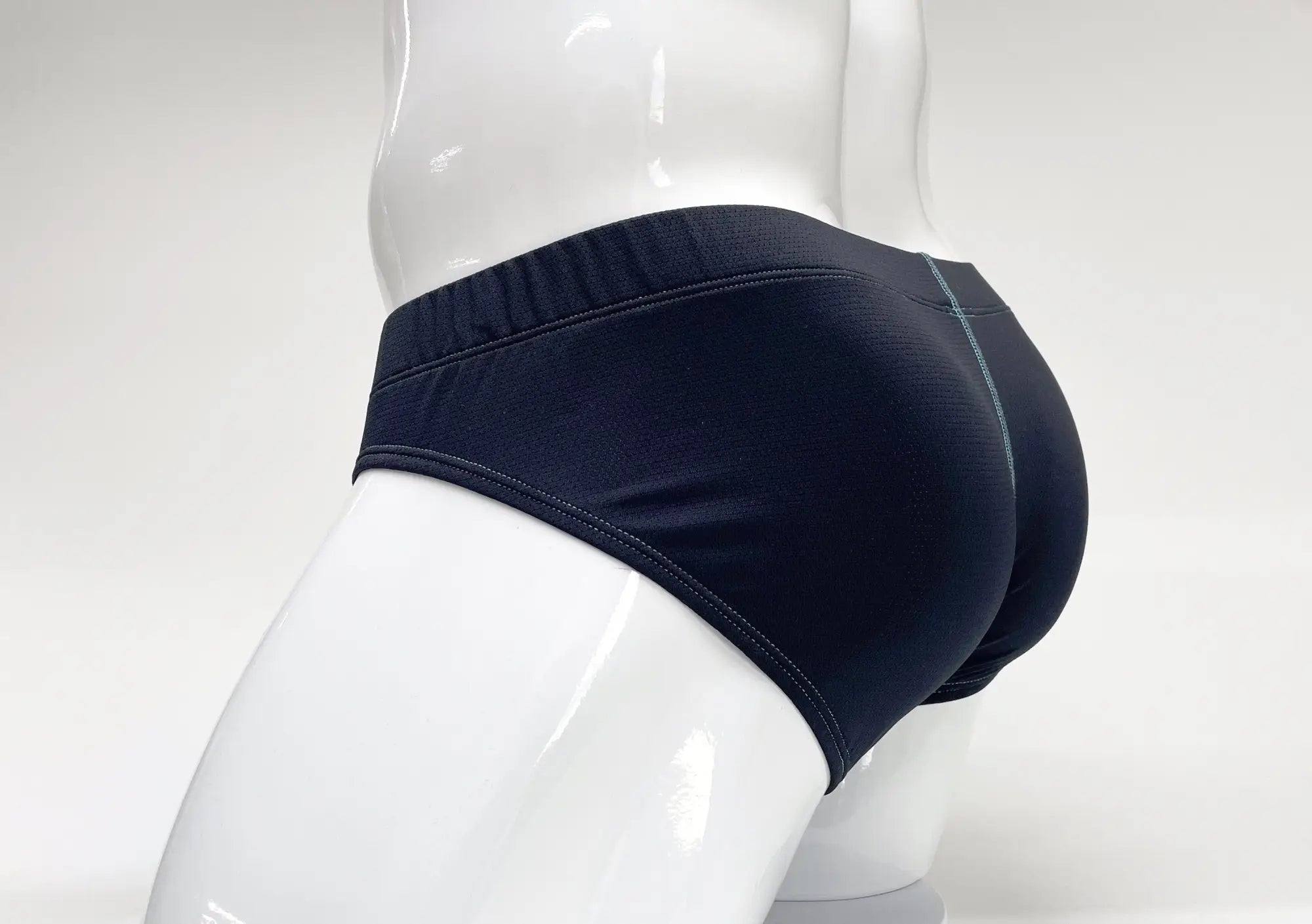 Stitch Big Boy Pouch Brief in navy blue on a white mannequin, showing back view with contrast teal stitching.