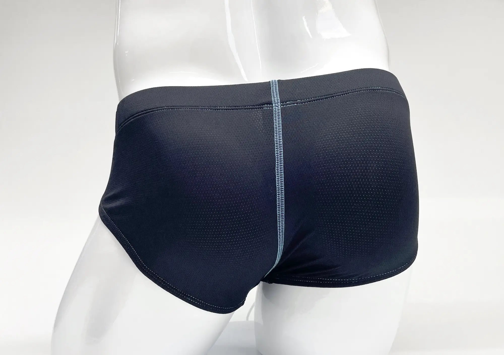 Blue, perforated-fabric brief on a white mannequin, featuring a contrasting light blue vertical center stitch.