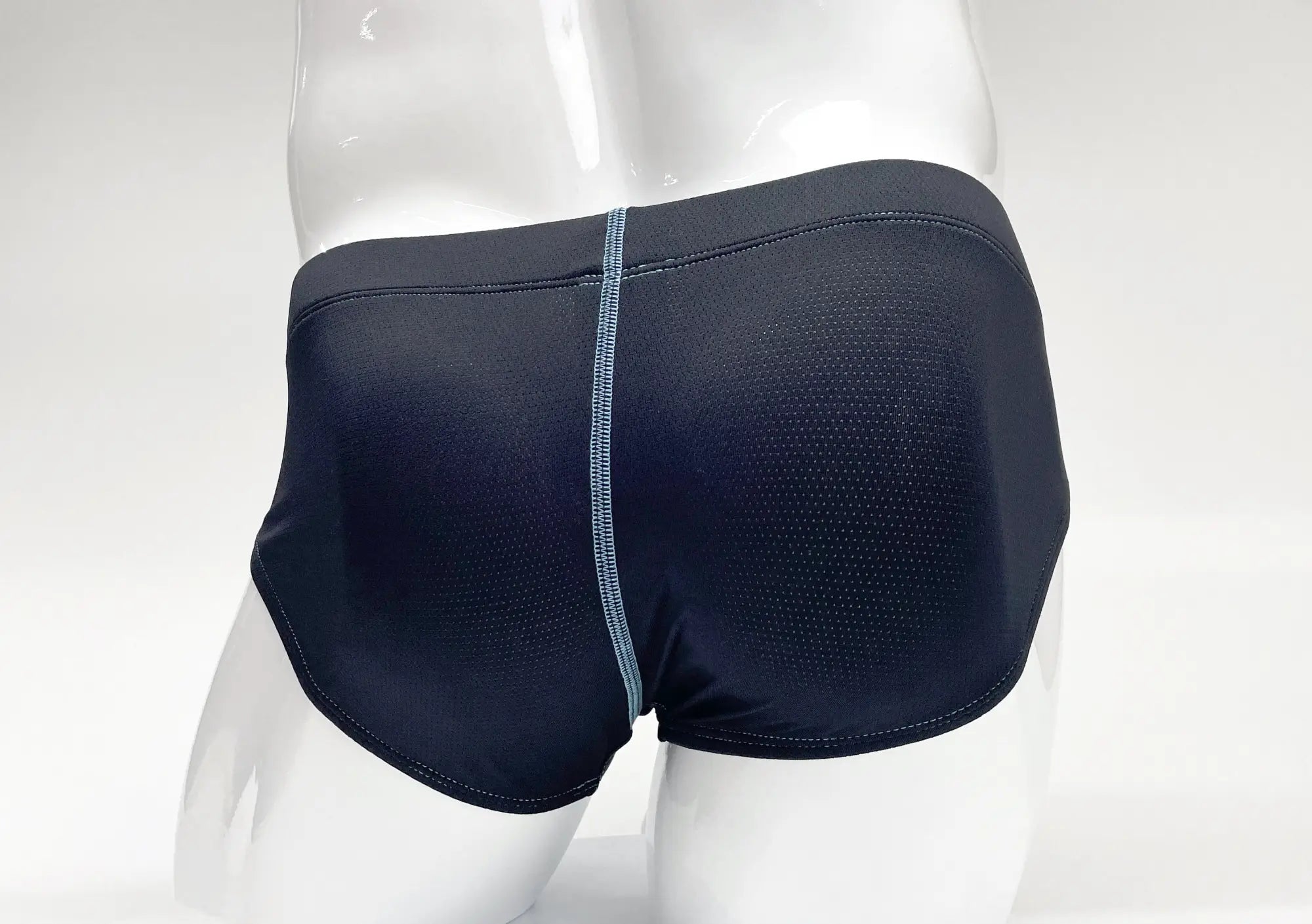 Blue perforated-fabric pouch brief on a white mannequin, featuring a contrasting light blue center back seam.