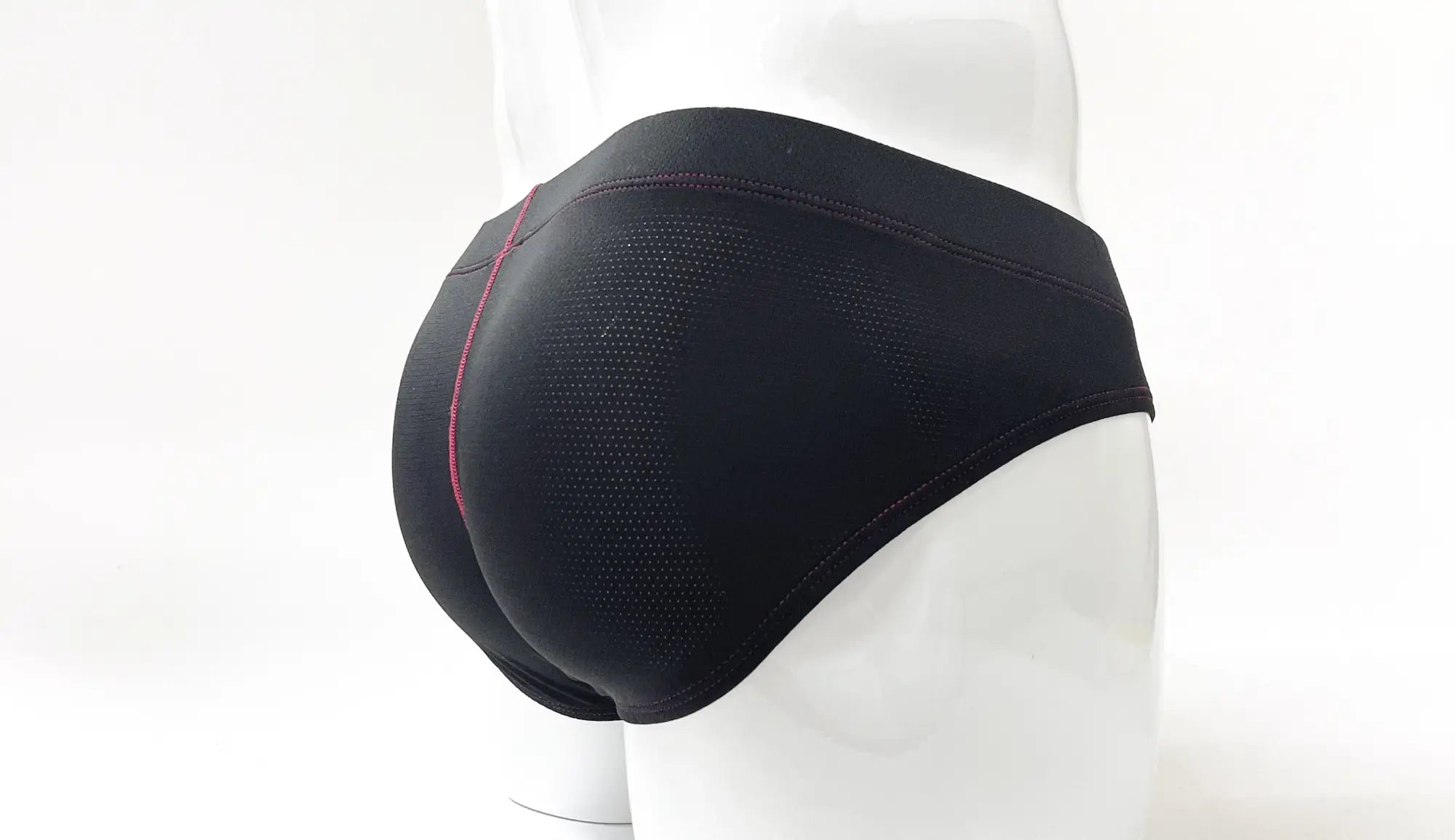 Black perforated fabric pouch briefs on a mannequin, featuring red contrast stitching details.