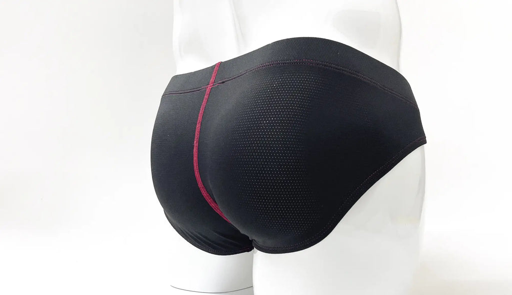 Black perforated pouch brief with red contrast stitching, shown from the rear on a mannequin.