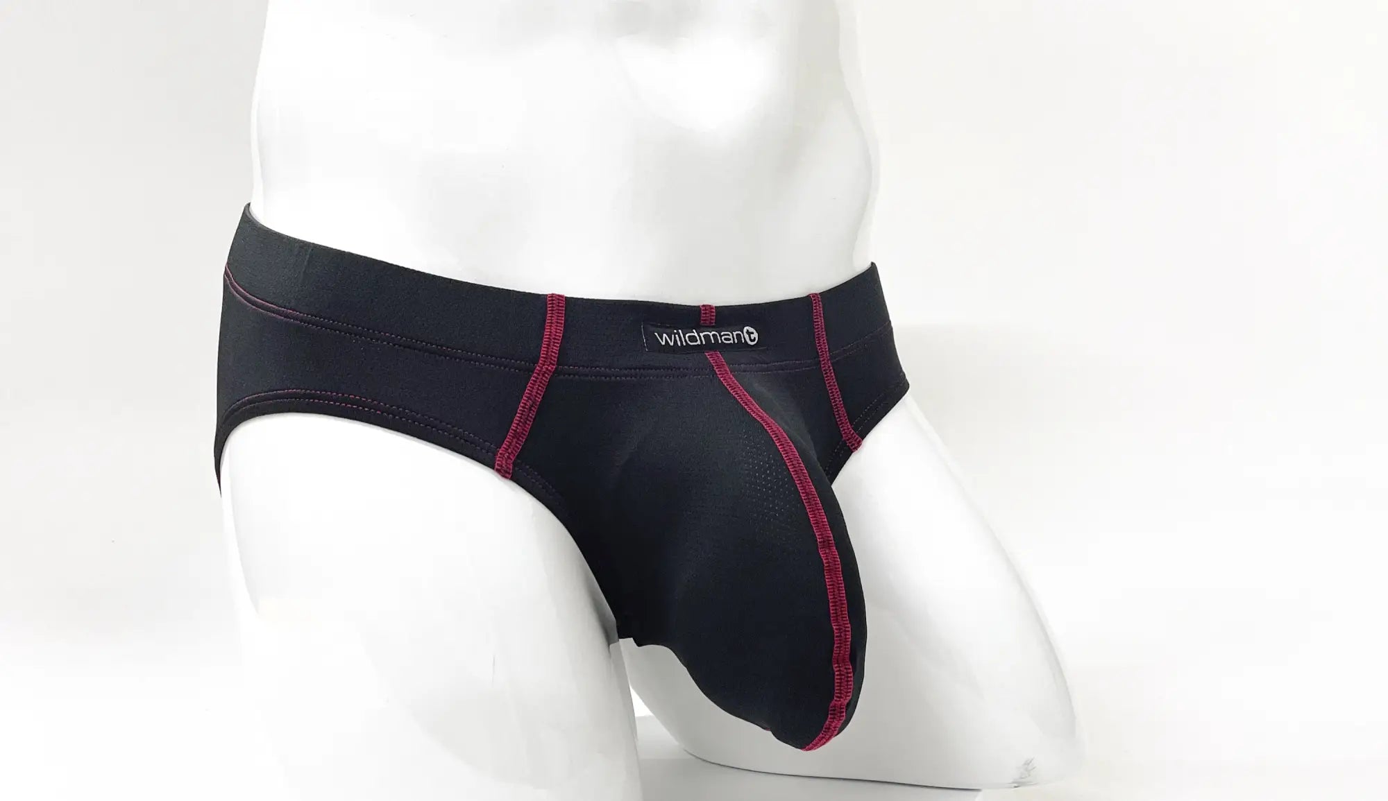 Black pouch brief with red contrast stitching and Wildman logo on the waistband, shown on a white mannequin.