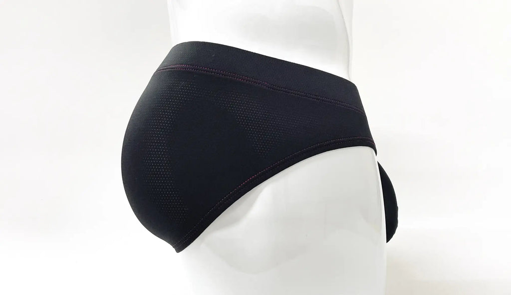 Black pouch brief on a mannequin, featuring perforated fabric and red stitch detailing along the waistband and seams.