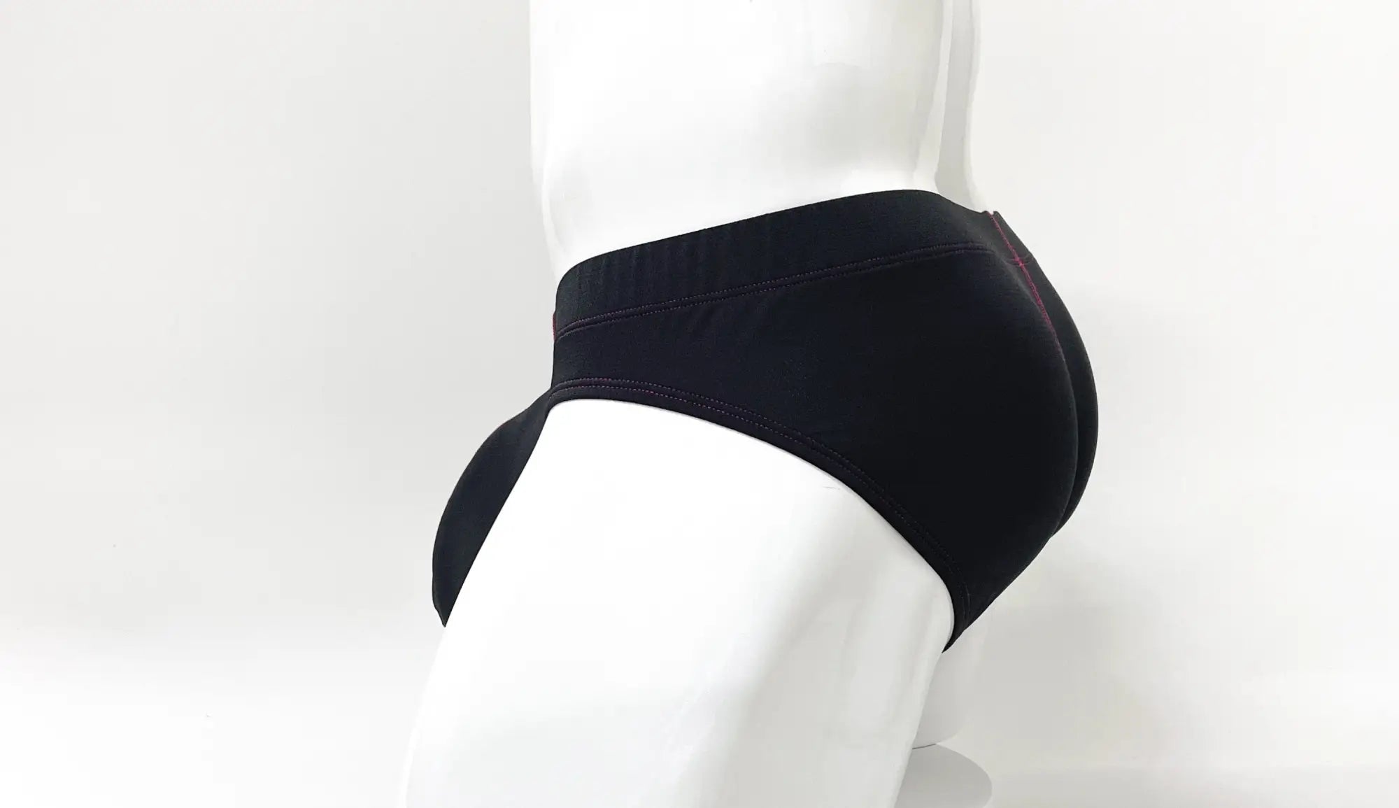 Side view of a black Stitch Big Boy pouch brief with subtle red stitching, worn on a white mannequin.